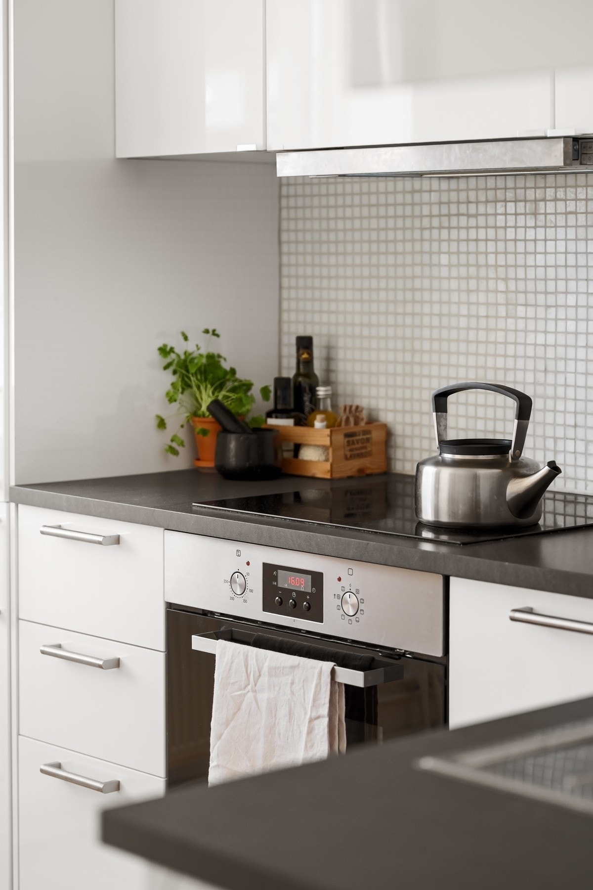 Benkeplate i laminat og mosaikkfliser mellom overskap og benkeplate. Galleribilde