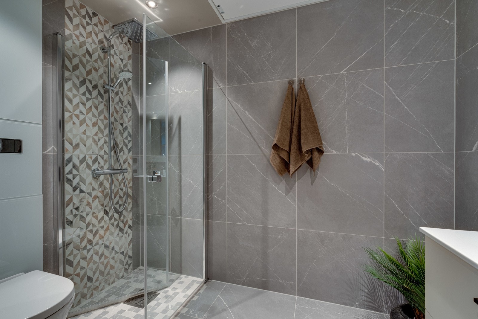 Leiligheten har et meget lekkert baderom med delikate 60x60 fliser på gulv og vegg, samt flotte dekorfliser i dusjsonen. Galleribilde