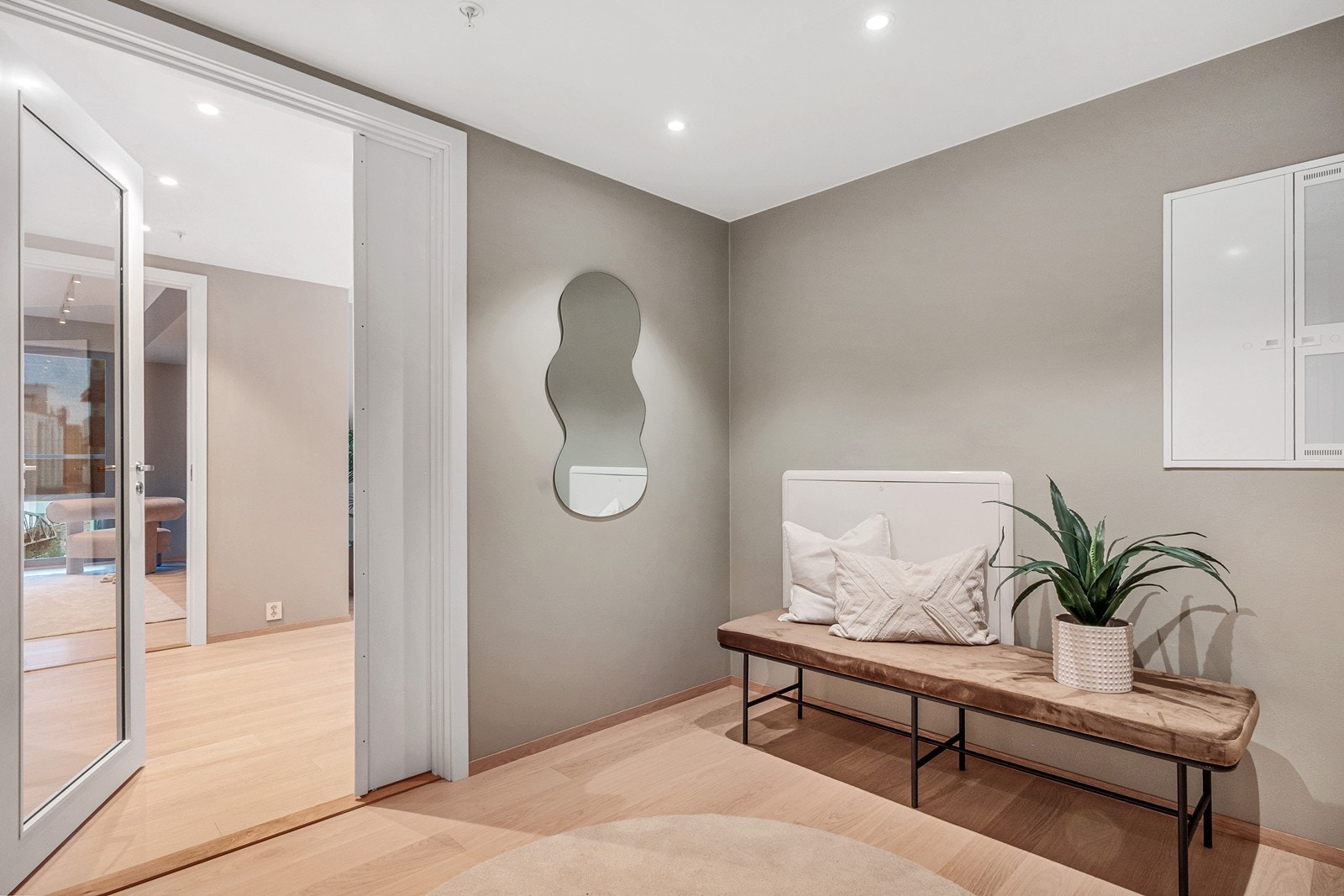 Entréen er lys og romslig, med tilgang til ett av boligens to bad, samt videre tilgang til stue og kjøkken. Galleribilde