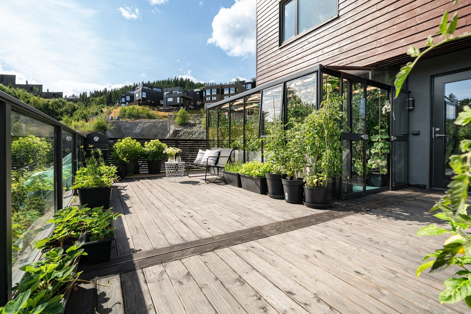 Stor uteplass med plass til både sittegruppe og egen kjøkkenhage i drivhus. Galleribilde