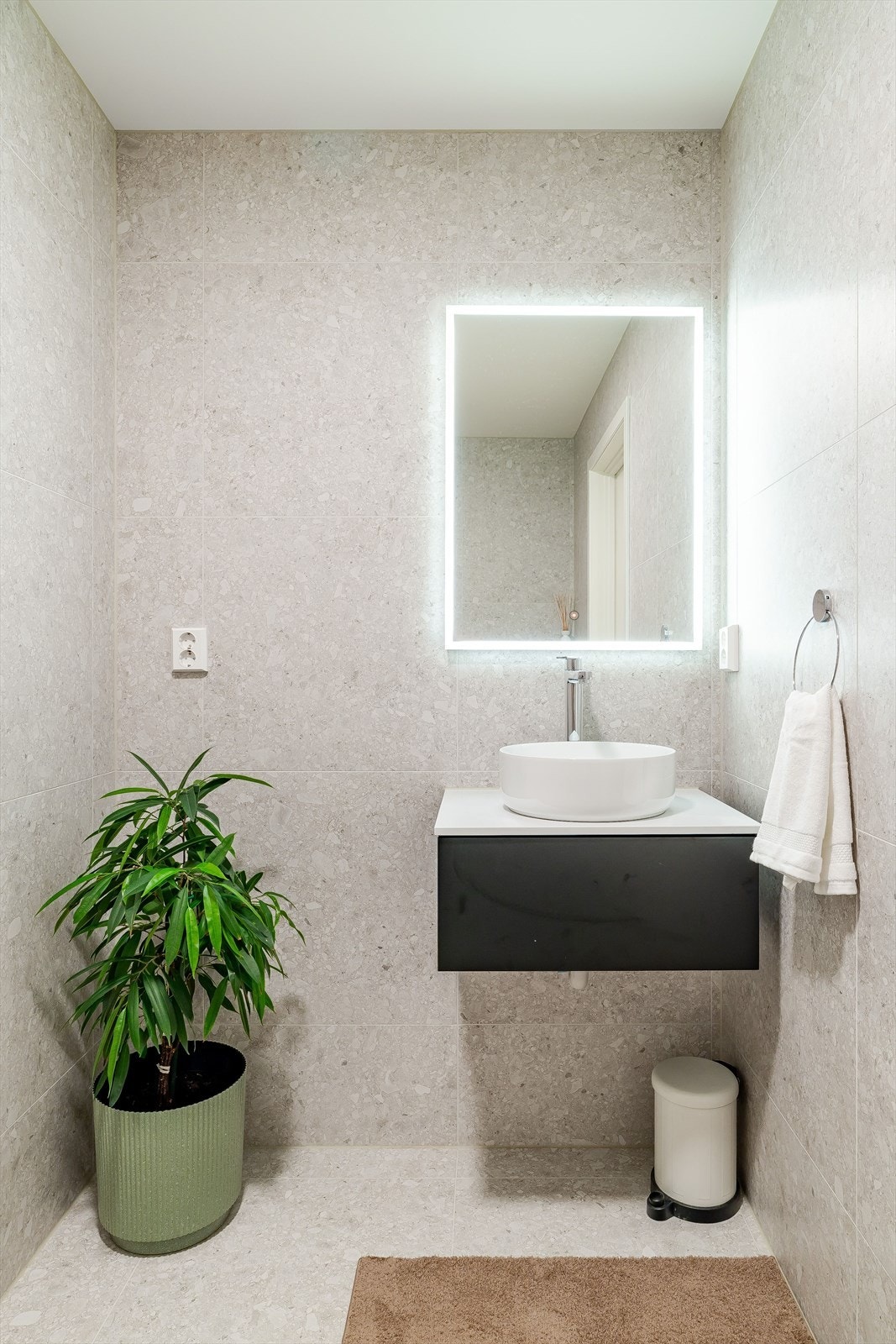 Stilrent baderom med vegghengt servantinnredning, rundt servantfat, belyst speil. Galleribilde