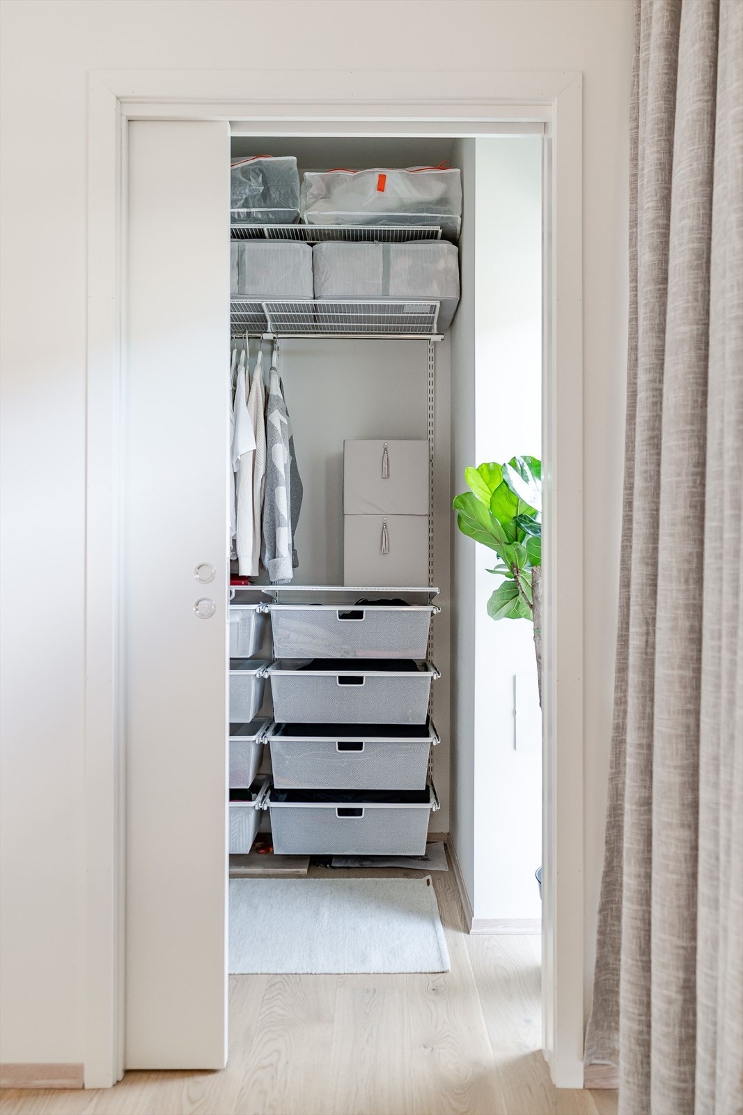 Praktisk walk-in garderobe med smart garderobeløsning med hyller, skuffer og klesoppheng fra Elfa. Galleribilde