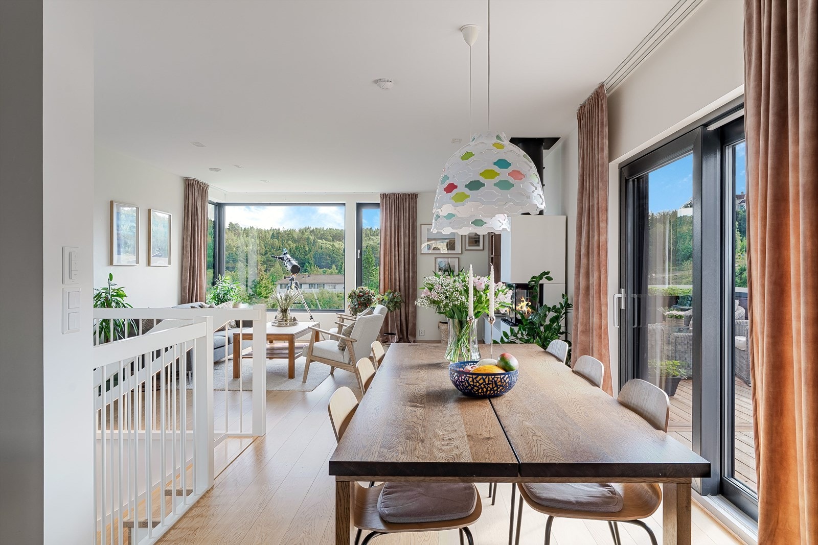 Åpen løsning mellom spisestue og stue, store vindusflater og flott utsikt mot grønne omgivelser. Galleribilde