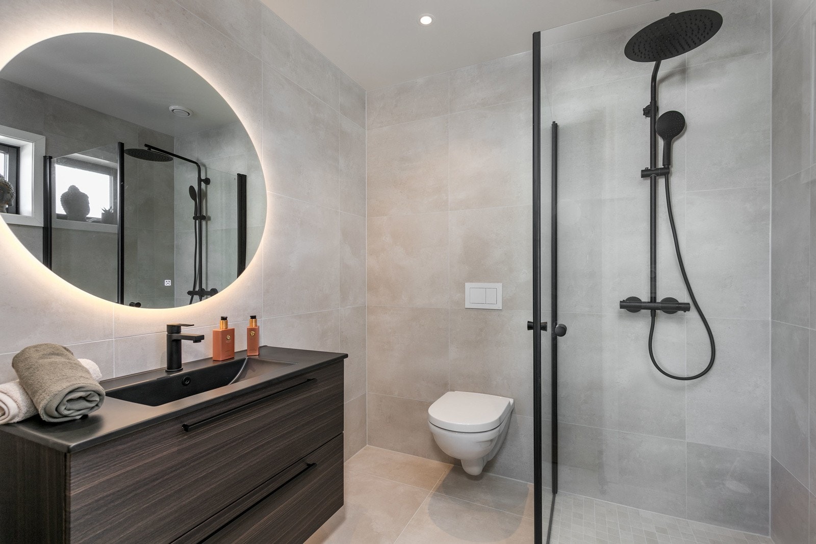 Lekkert bad i tilknytning til hovedsoverom. Delikate fliser av typen Glade Branco Mate Rect 60x60 og Glade Branco Mate 5x5 cm i dusjgulvet. Det er dusjvegger fra Lucca, baderomsinnredning av type Como 90 standard i amerikansk valnøtt Galleribilde