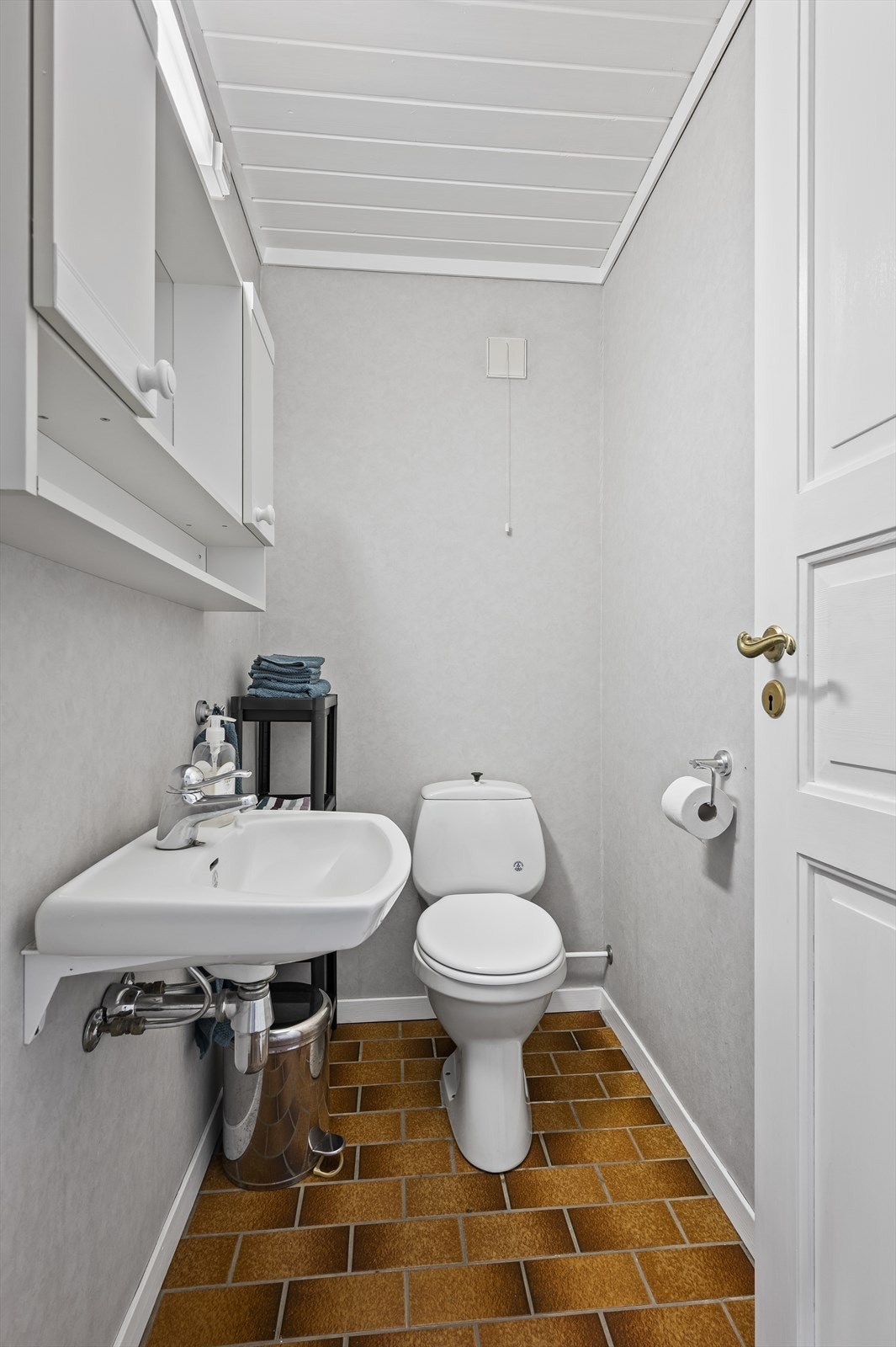 Separat toalettrom utstyrt med toalett, servant og speilskap Galleribilde