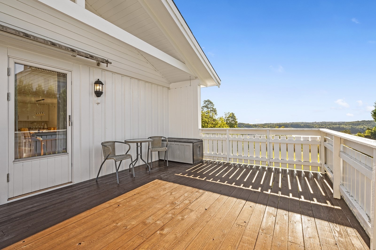 Uteområdet utenfor stuen består av en stor treplatting som er delvis overbygget. Det er montert en stor markise over døren inn til stuen Galleribilde