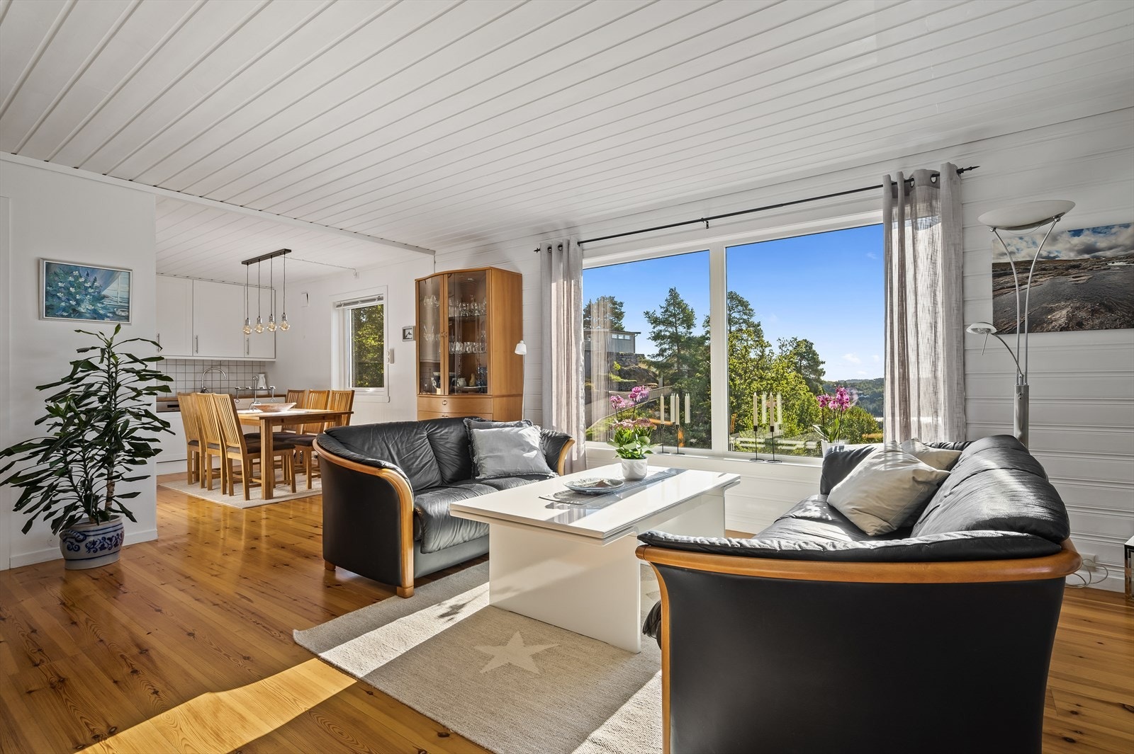 Romslig og pen stue med lysmalte overflater og lakkerte tregulv Galleribilde