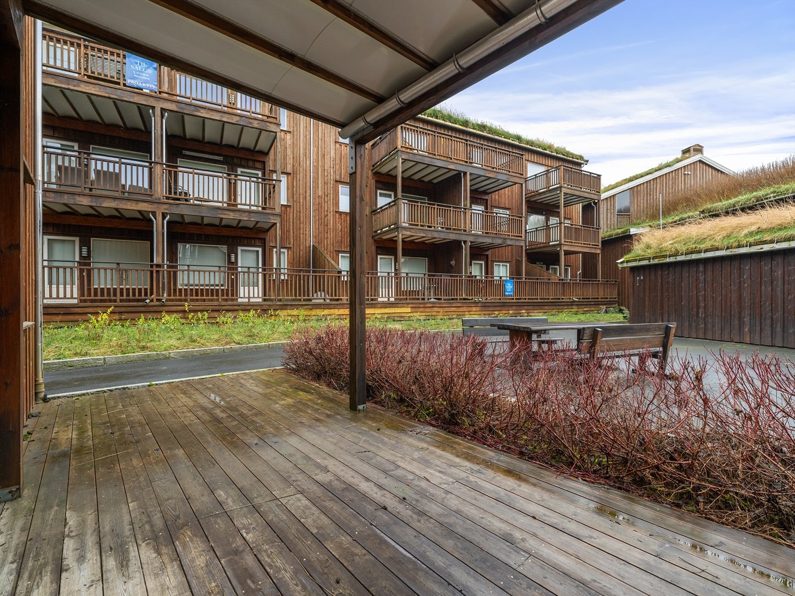 Markterrasse med både overbygg og levegg. Solrikt og skjermet tun. Kjekk hekk plantet i front for mindre innsyn, og et grønt utsyn. Galleribilde