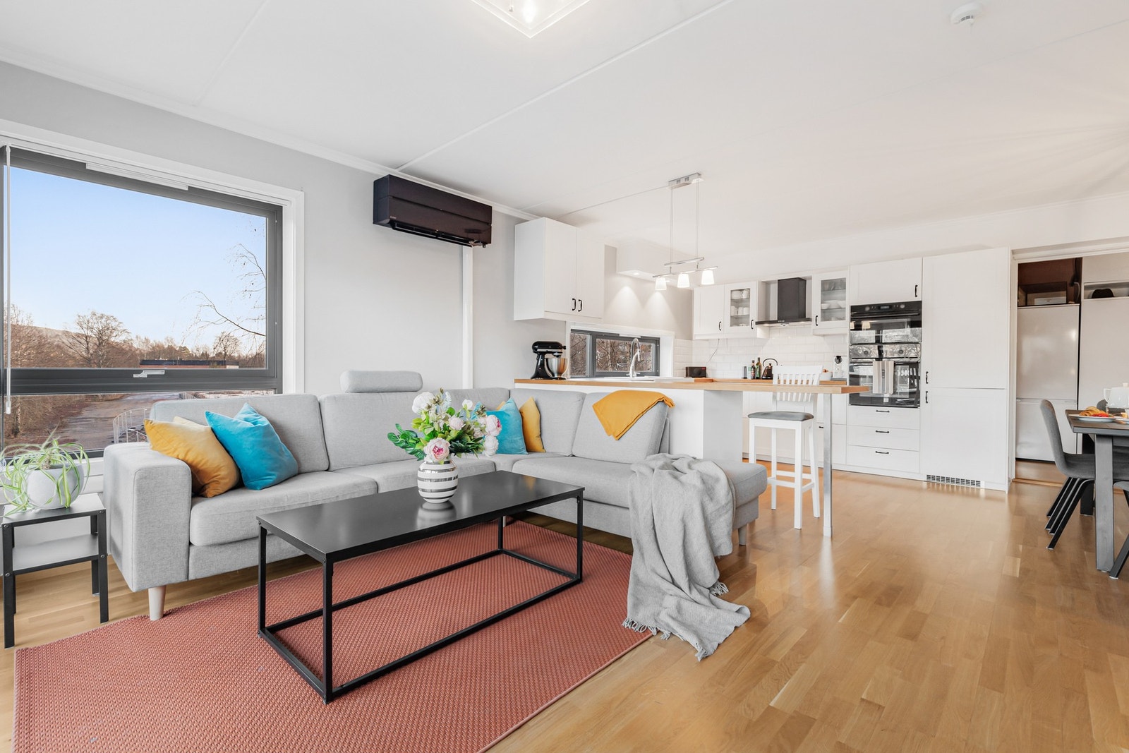 Lys og innbydende stue med praktisk skille mellom kjøkken og stue. Galleribilde