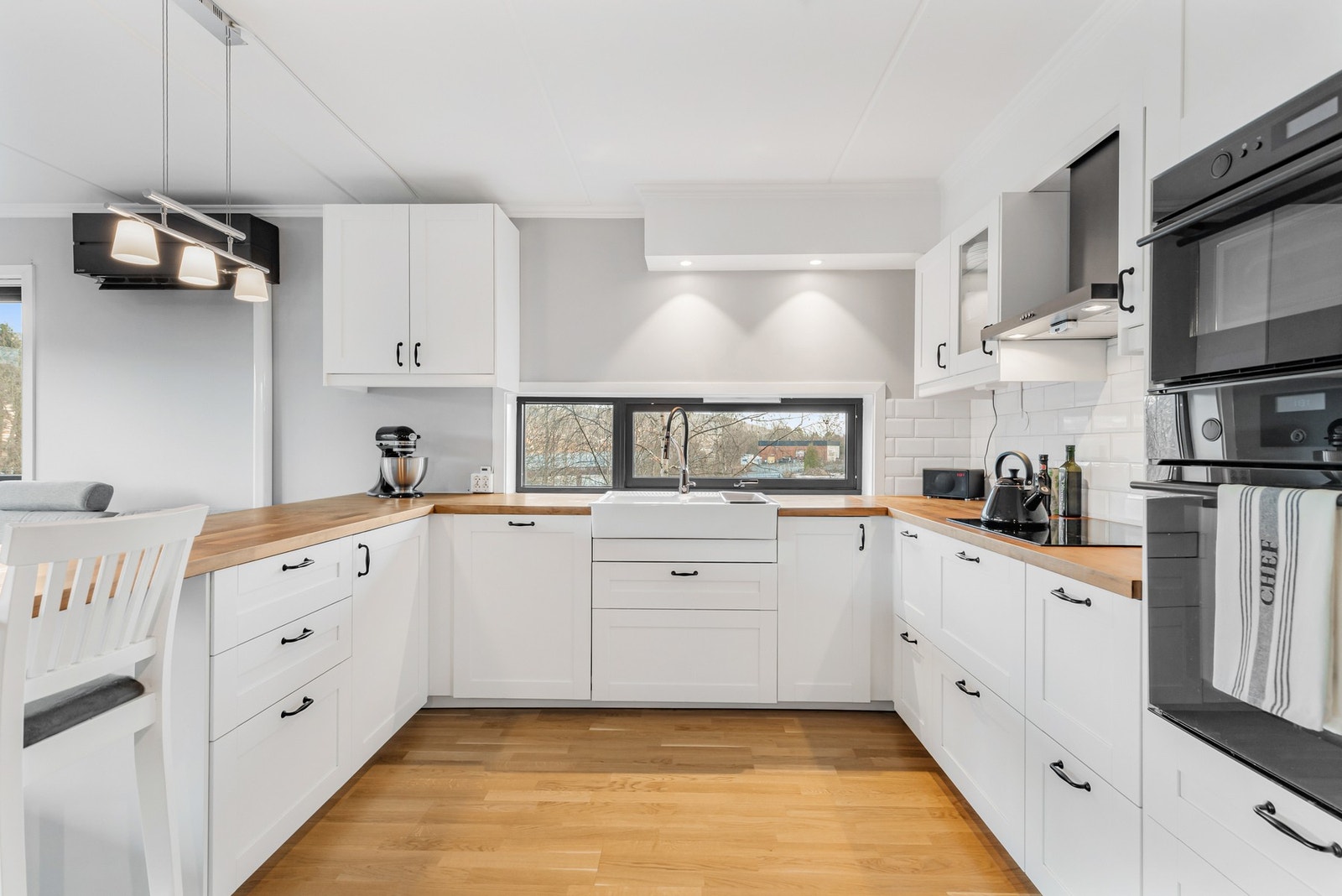 Videre er innredningen utstyrt med integrerte hvitevarer, herunder kjøl/fryseskap, stekeovn, platetopp, oppvaskmaskin og mikrobølgeovn Galleribilde