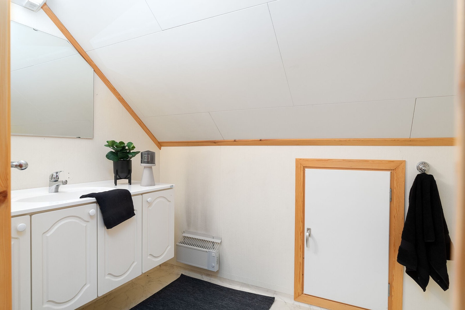 Toalettrom som er innredet med servant på innredning, og gulvmontert toalett. Galleribilde