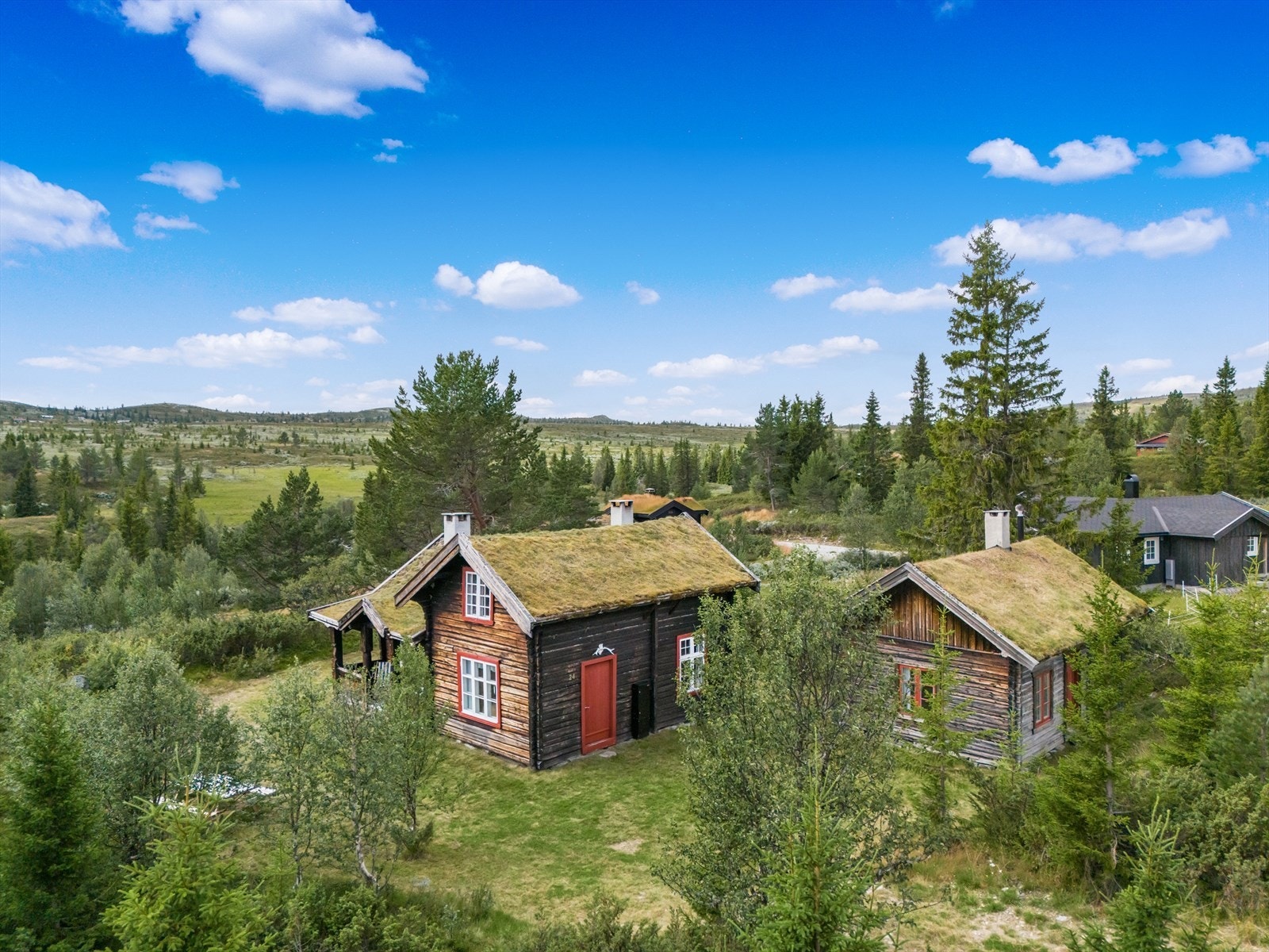 På hytteveggen er det montert elbil lader. Det er god plass til parkering av flere biler ved hytta. Galleribilde