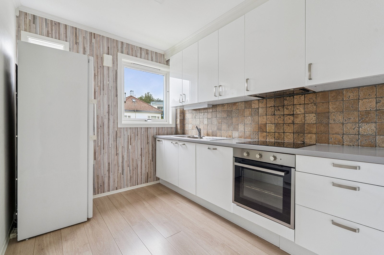 Moderne kjøkken med hvite fronter, god benkeplass og naturlig lys. Galleribilde