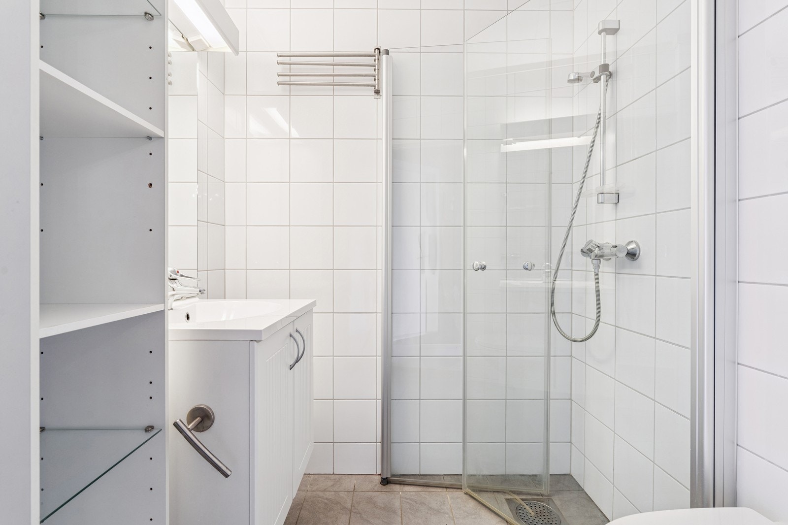 Flislagt med dusjhjørne, servant og toalett – praktisk for en stor husholdning. Galleribilde