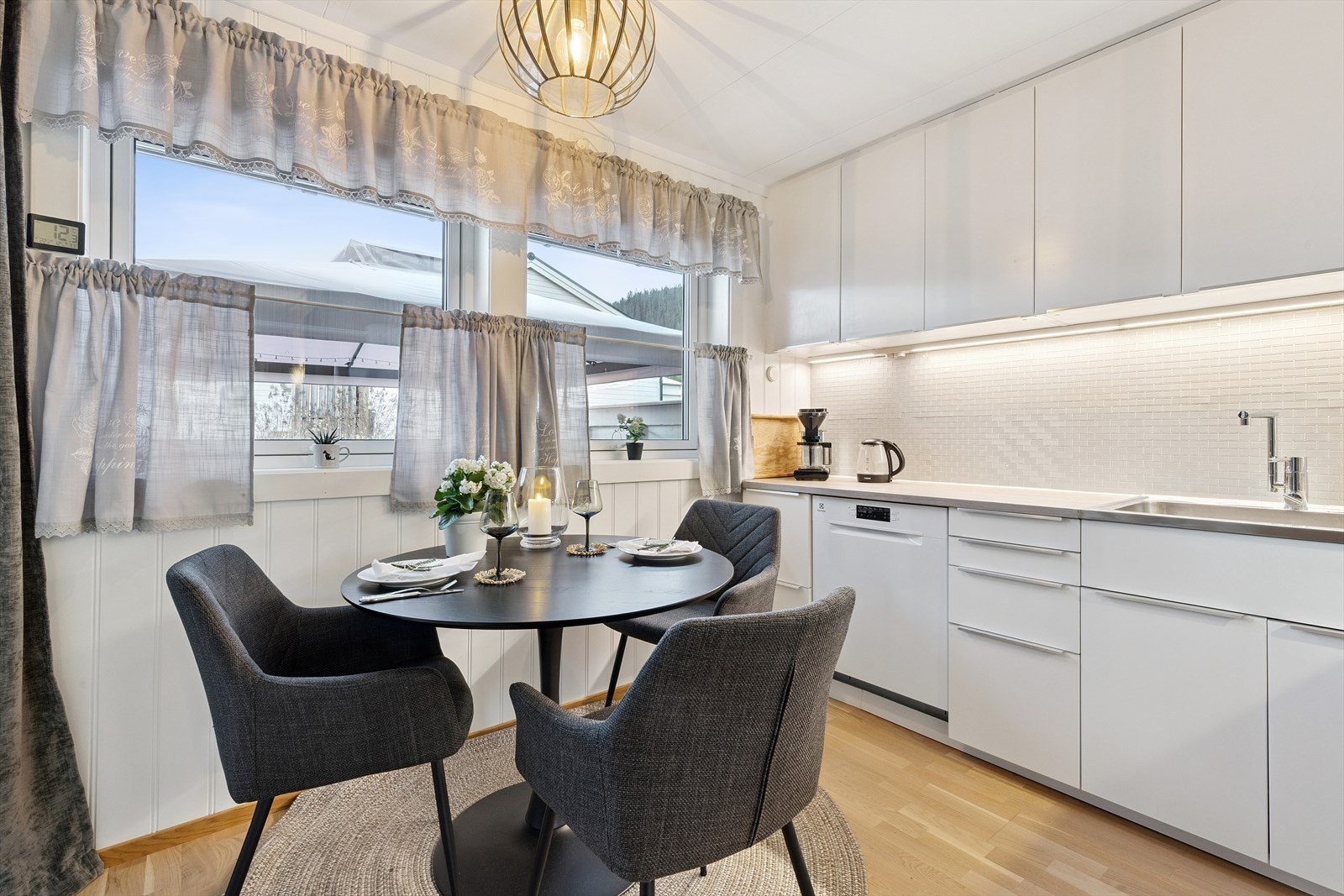 Takhøye overskap gjør at du slipper støvsamleren. Det er montert lys under overskapene og man har pene fliser i en lys turkis-tone som står godt i stil til de lyse overflatene. Galleribilde