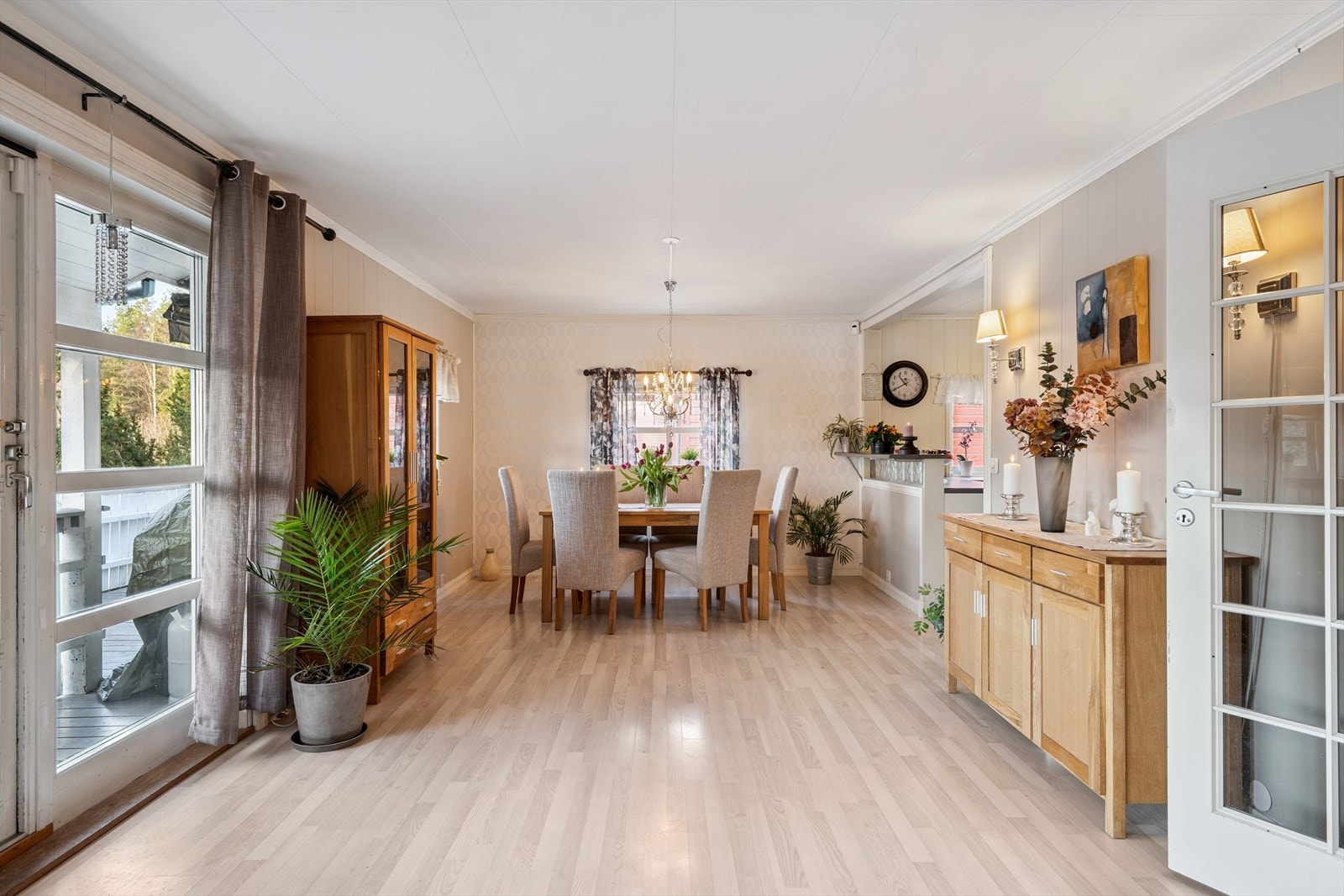 Veggen i enden ved spisestuen er tapetsert og gir en fin brytning til de ellers lyse veggene. Galleribilde