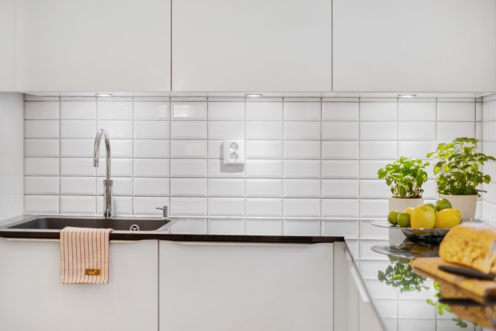 Det er lagt fliser mellom benkeplate og overskap. I tillegg er det installert en quooker som gir kokende vann ut fra springen Galleribilde