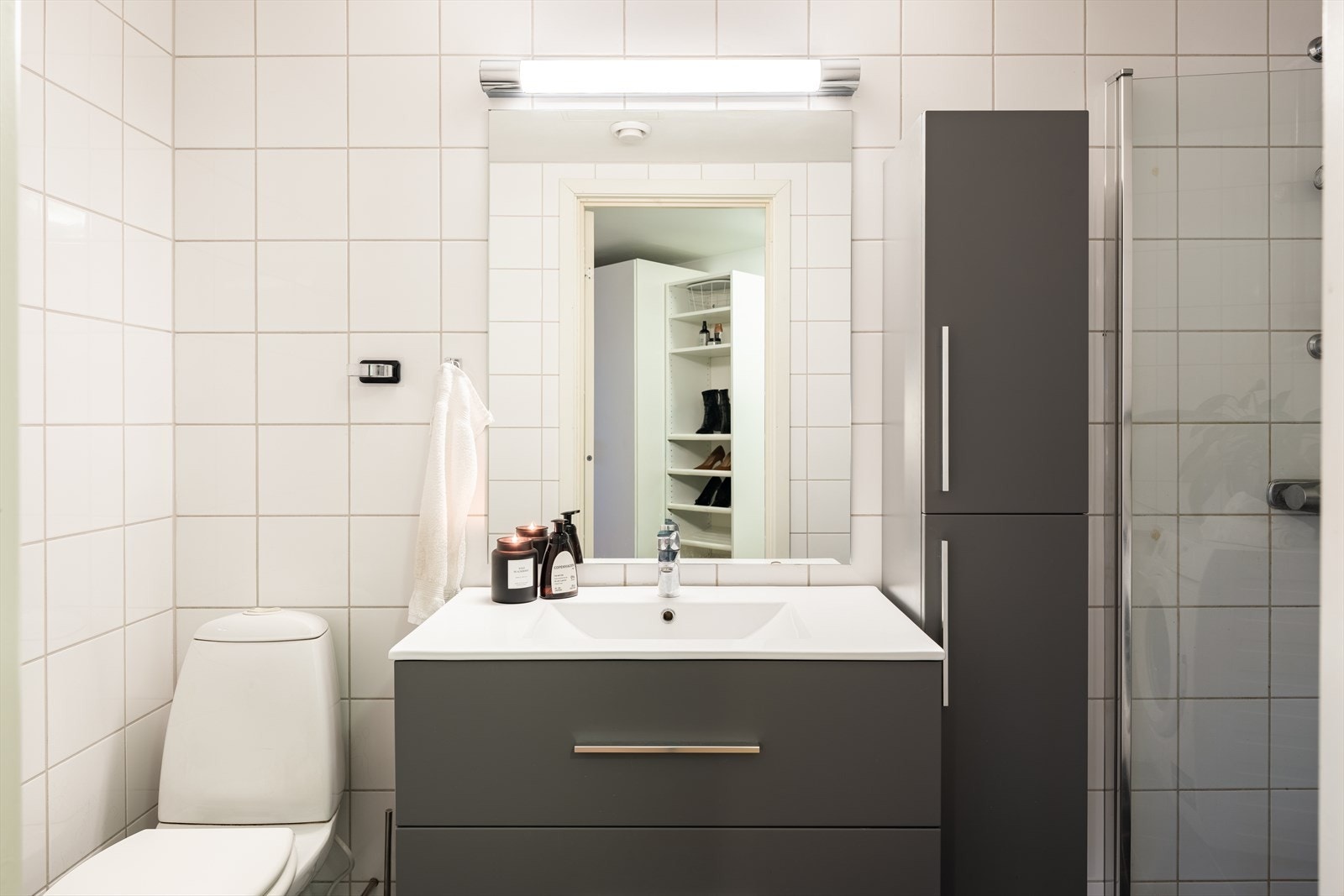 Badet byr på veggmontert innredet servant, innfellbare dusjdører, toalett og opplegg for vaskemaskin. Galleribilde