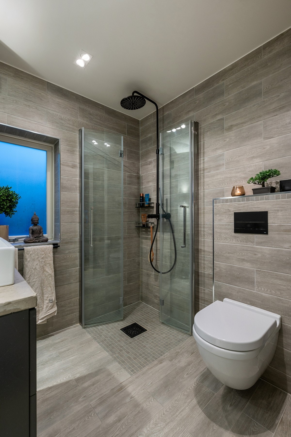 Baderommet er utstyrt med servantinnredning, vegghengt toalett og dusjhjørne med glassdører. Galleribilde