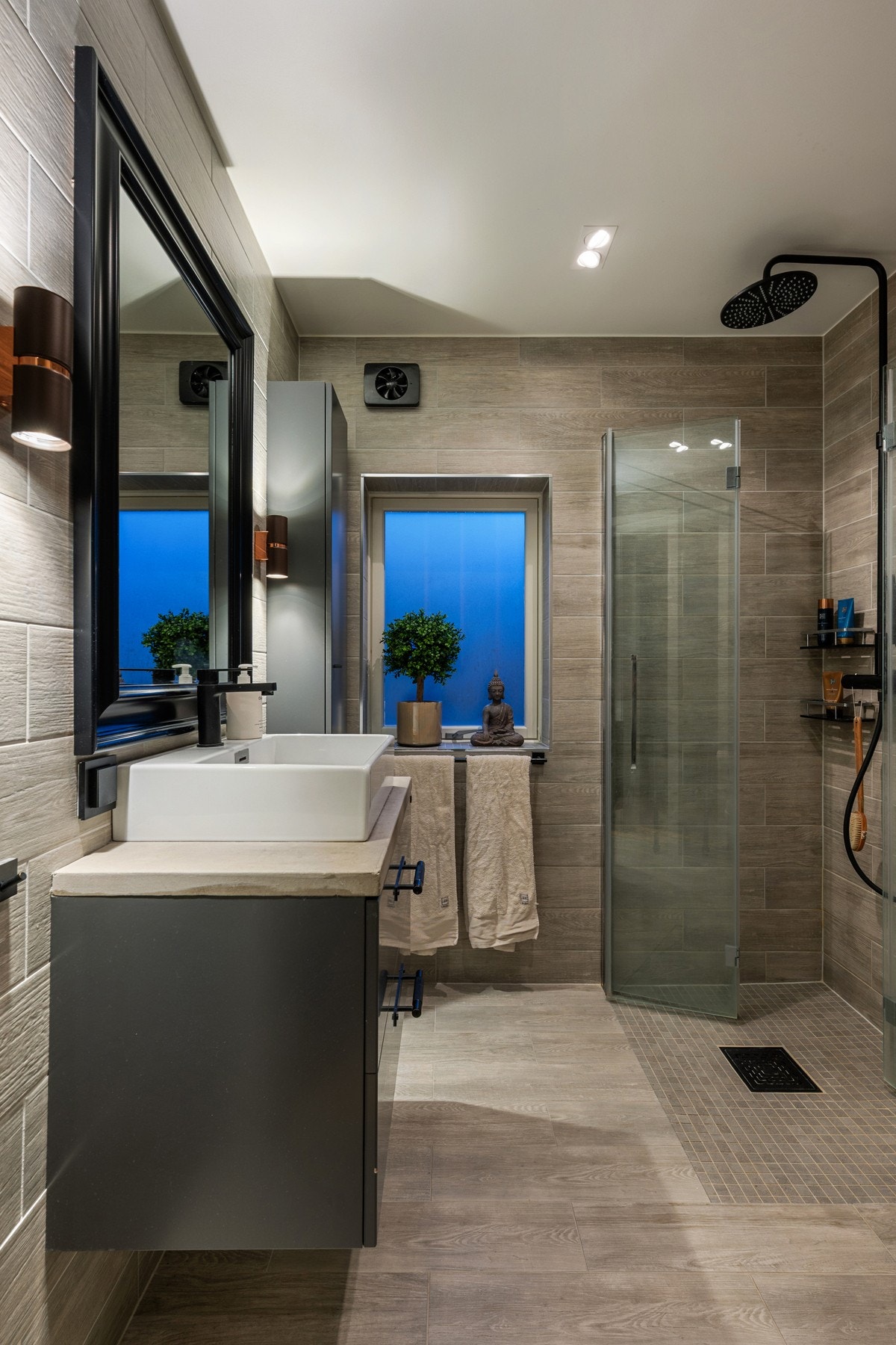 Delikat og moderne bad med flislagte vegger og gulv, utført i tidløse materialvalg. Galleribilde