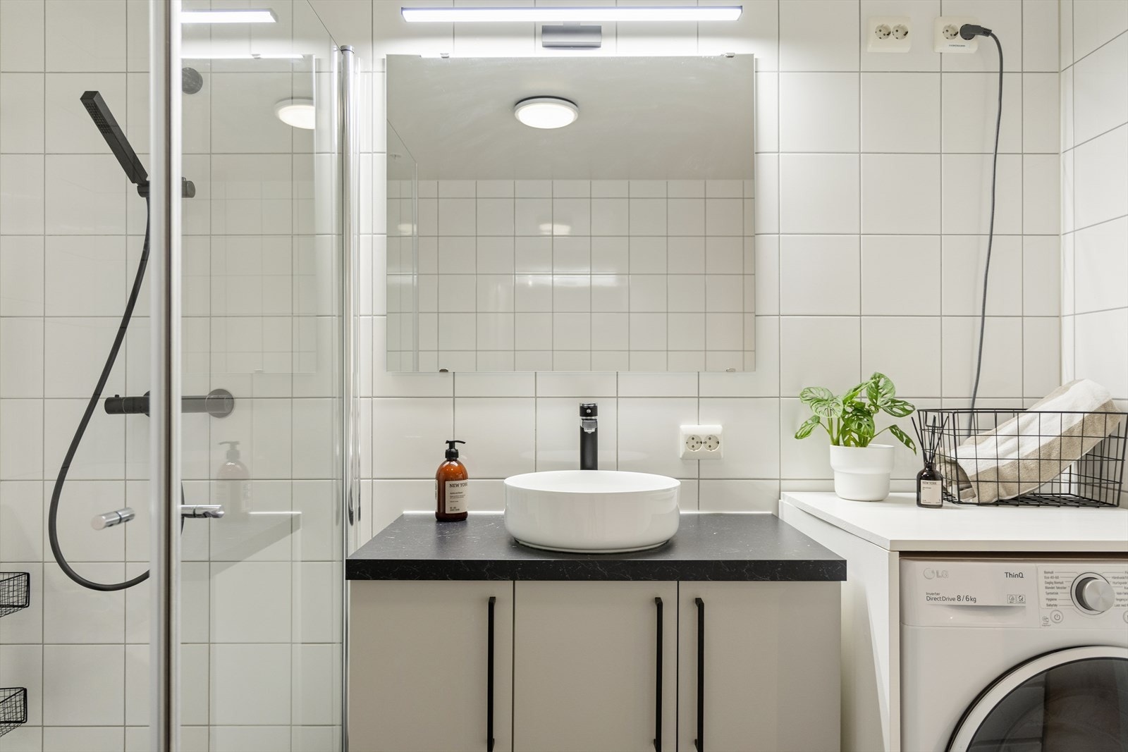 Baderomsinnredningen er modernisert med ny vask, benkeplate og armatur. Vaskemaskinen har en praktisk, innebygd hylle over, som gir enkel oppbevaring av håndklær og lignende. Galleribilde