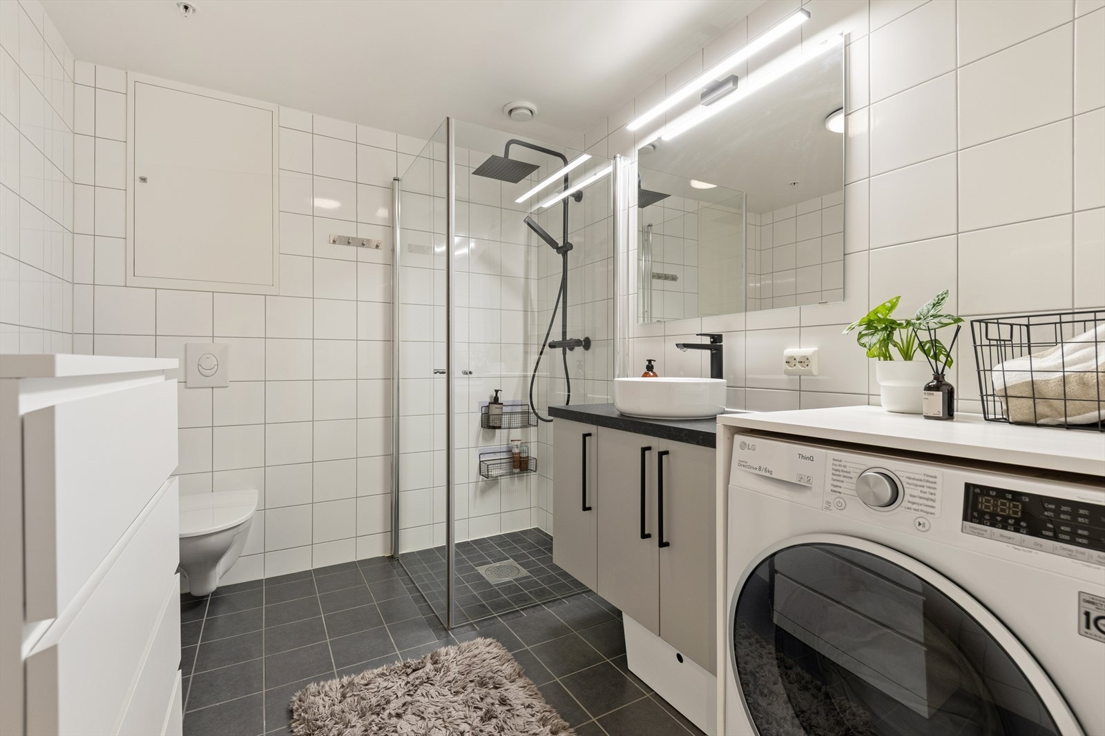 Badet er stilrent og moderne, med lyse farger, veggmontert toalett, dusjsone med nyere rainshower og blandebatteri. Galleribilde