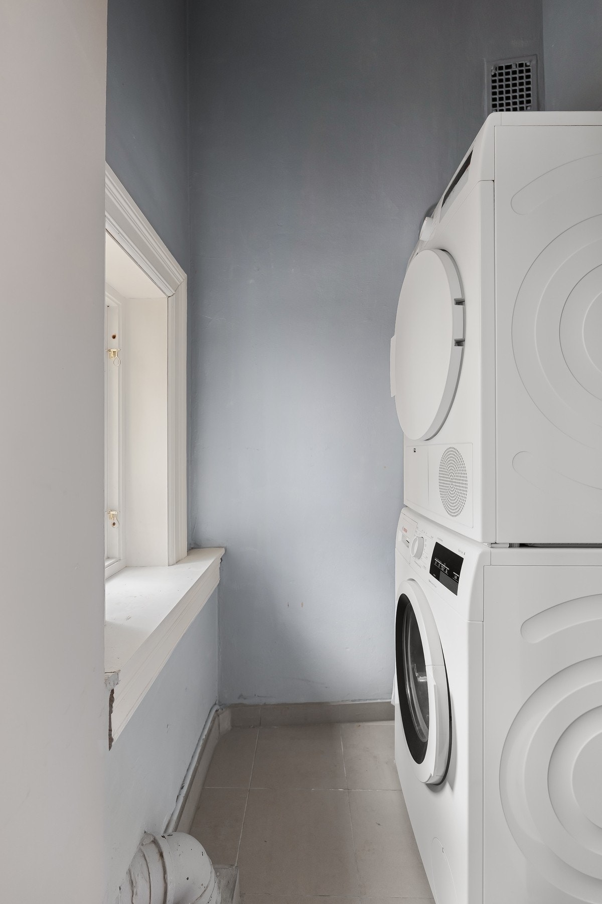 Bod med vaskemaskin og tørketrommel ligger vegg-i-vegg med badet. Galleribilde