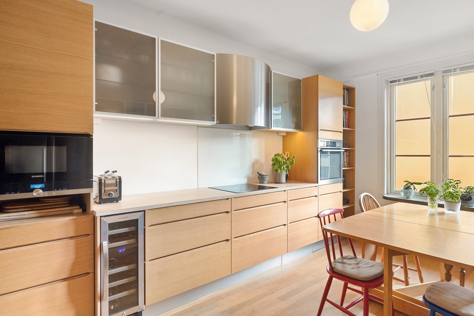 Stilig HTH-kjøkken fra 2015 med glatte fronter i eik, enkelte overskapsfronter med glass og benkeplate i bambus. Galleribilde