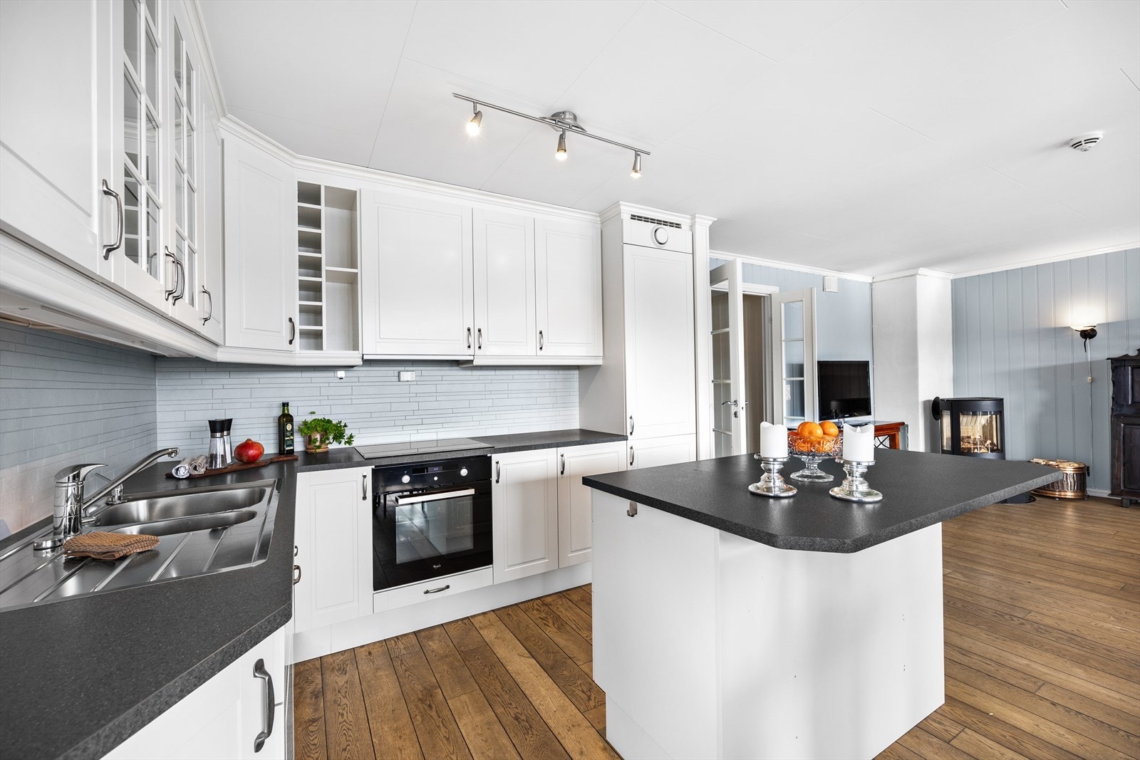 Innredningen er hvit med profilerte fronter, laminat benkeplate og vitrineskap. Galleribilde