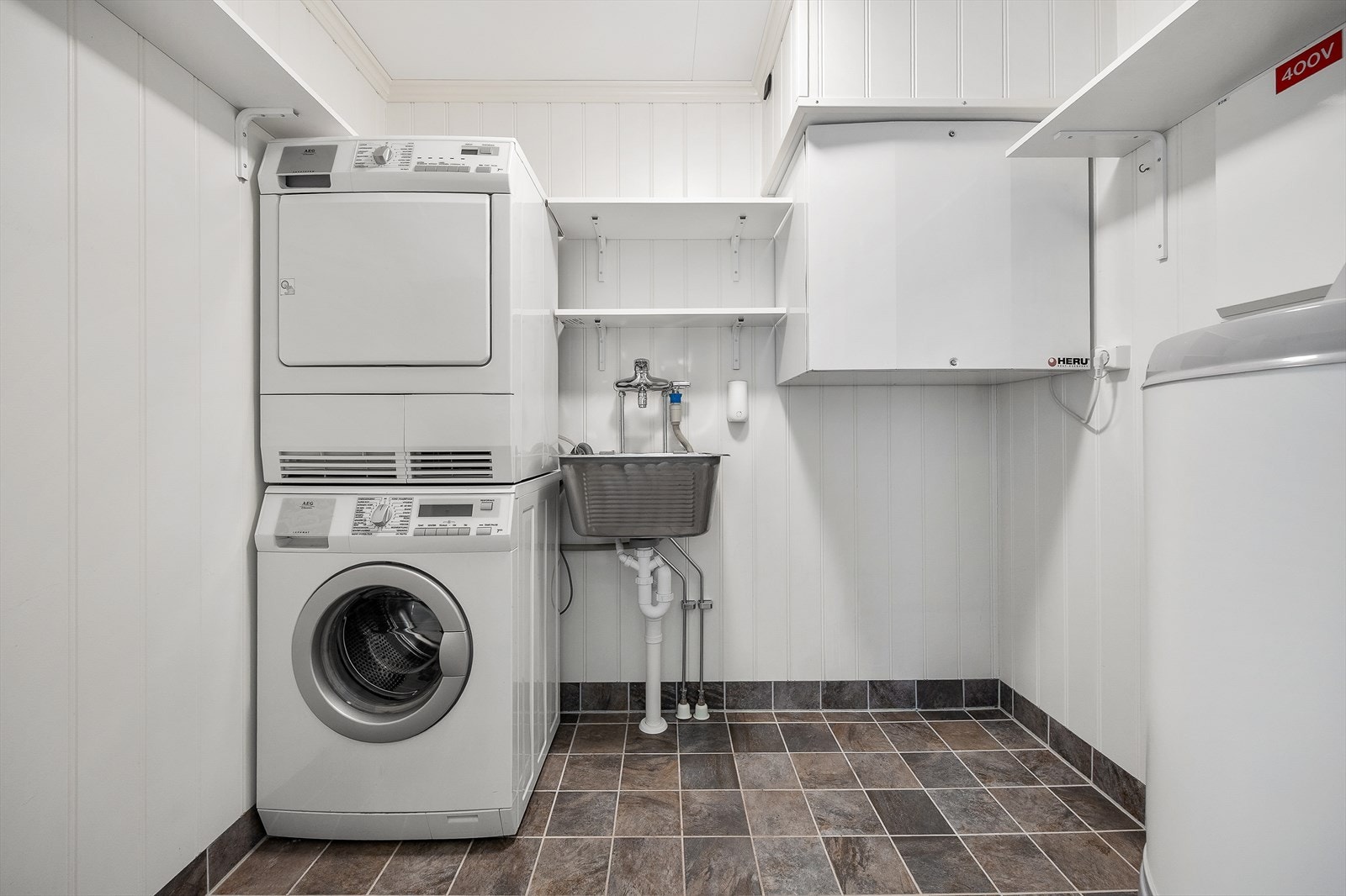 Vaskerom av god størrelse med belegg på gulv og panelte overflater. Galleribilde