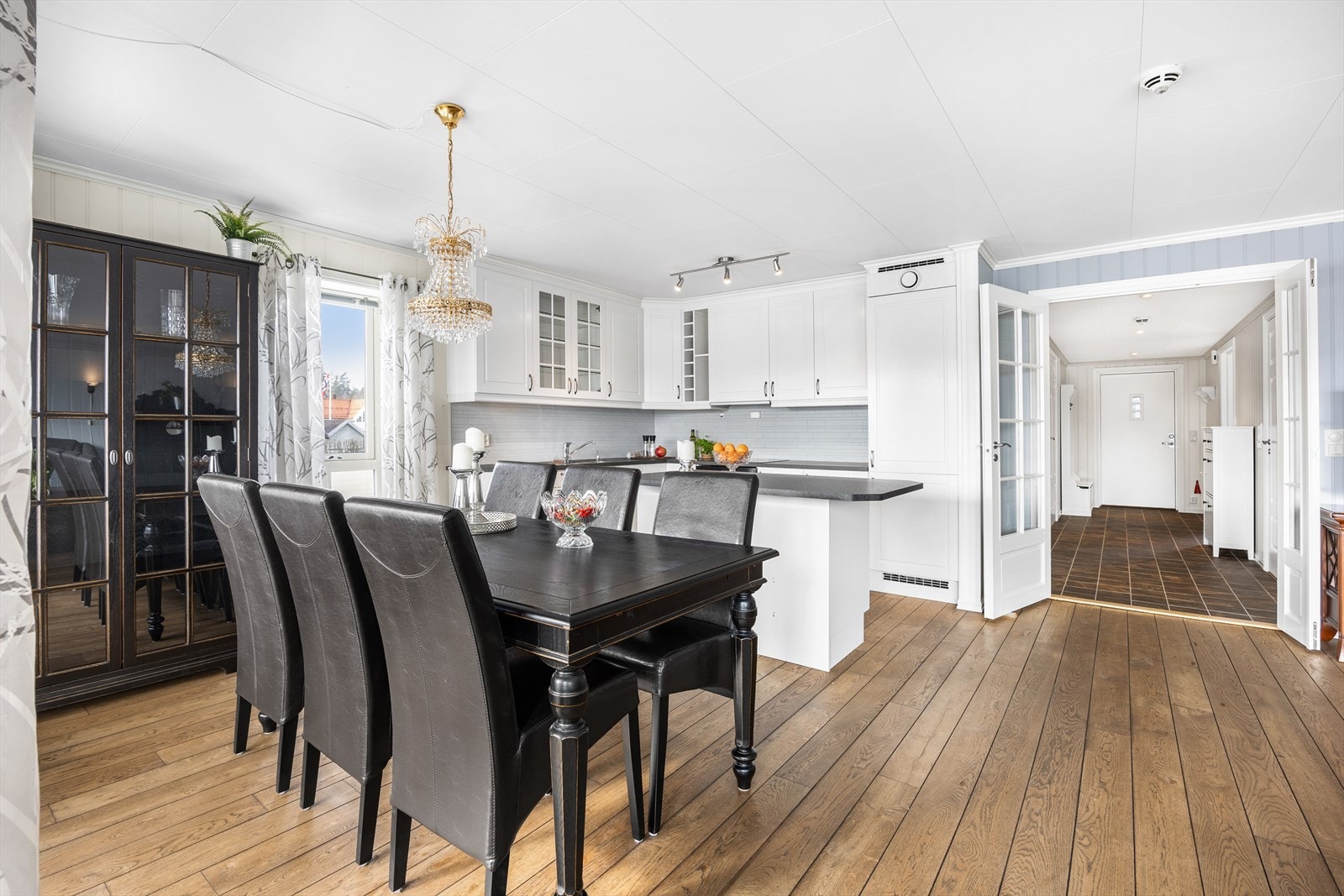 Pent og klassisk kjøkken i åpen løsning med stue. Galleribilde