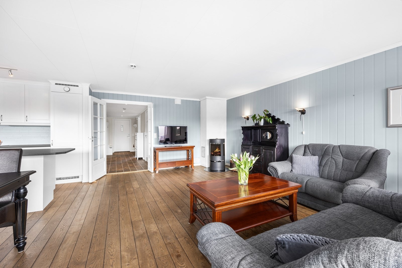 Peisovnen sørger for varme til hele leiligheten, overflatene er lyse og rommet framstår med en behagelig atmosfære. Galleribilde