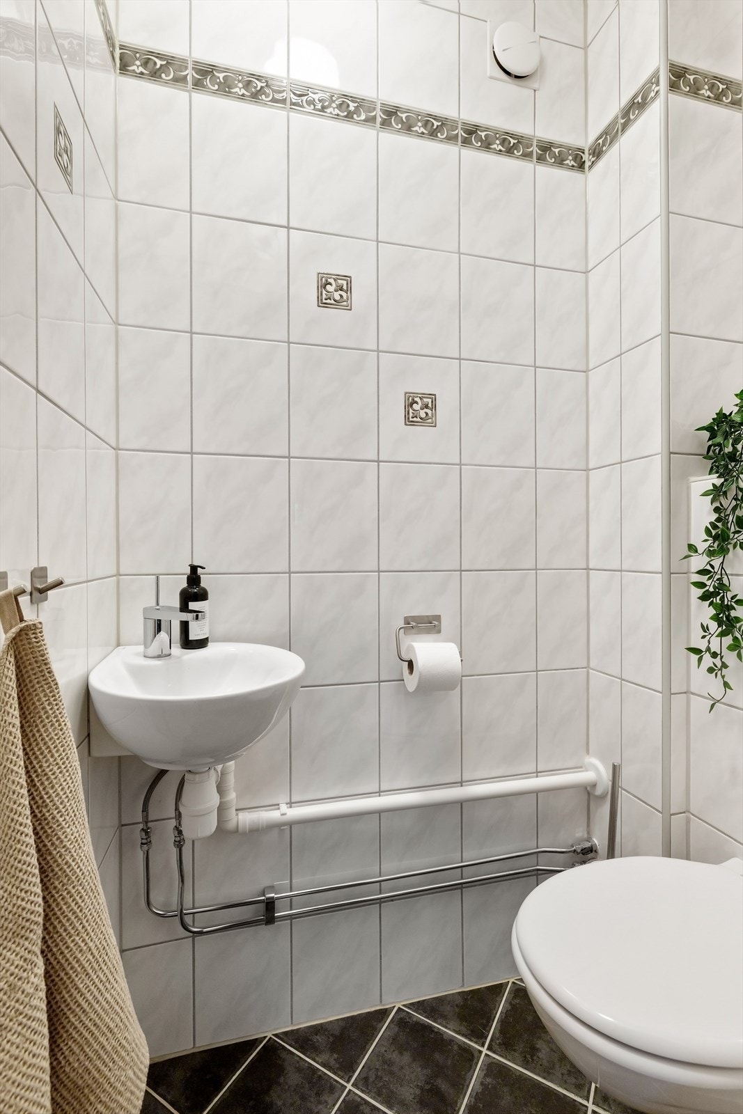 Separat toalettrom fra 2009 med vegghengt servant med ett-greps armatur og vegghengt toalett med innebygget sisterne Galleribilde