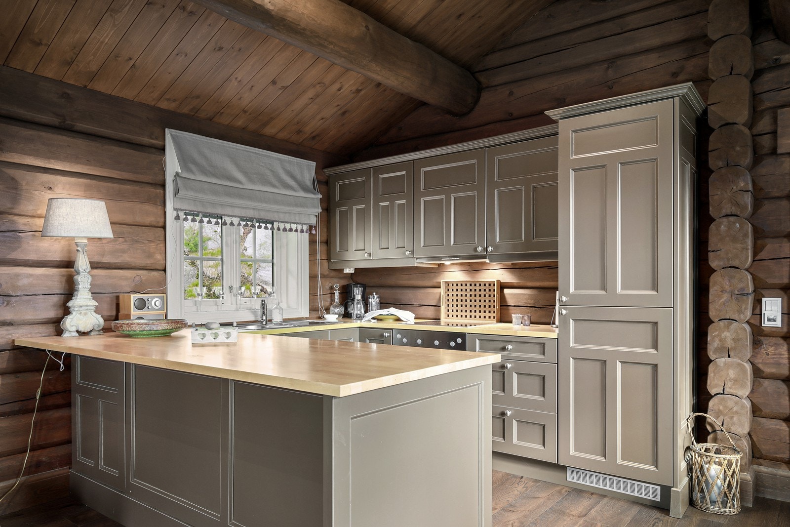 Kjøkkeninnredning med profilerte fronter og heltrebenkeplate. Kjøkkenet er utstyrt med integrert oppvaskmaskin, -kjøl/fryseskap og komfyr/platetopp. Galleribilde