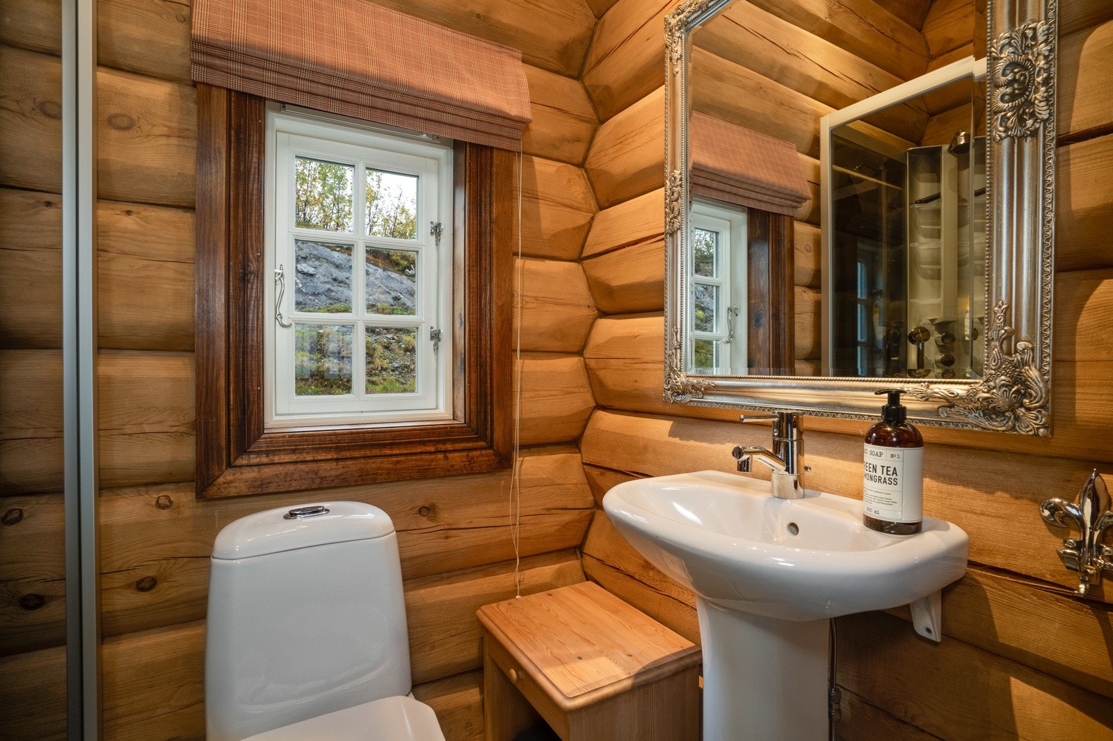 Baderommet i annekset har fliser på gulv, elektrisk gulvvarme, dusjkabinett, toalett og porselenservant. Galleribilde