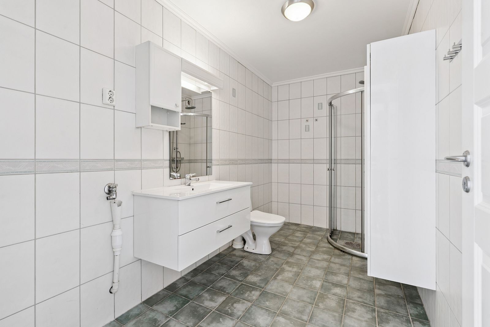 Komplett flislagt bad med opplegg for vaskemaskin og god oppbevaringsplass. Galleribilde