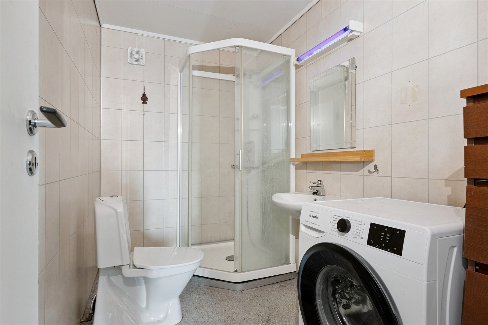 Baderom i utleiedel utstyrt med servant, dusjkabinett og opplegg for vaskemaskin. Galleribilde