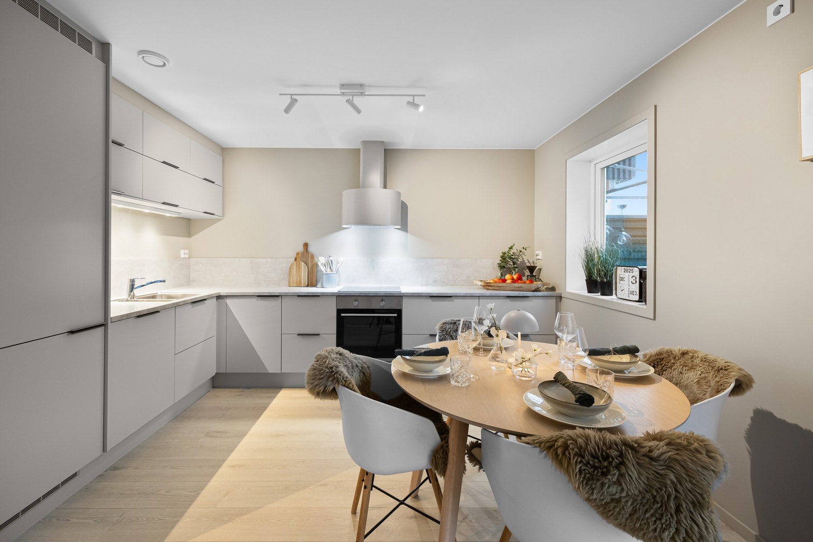 Moderne og stilrent Sigdal-kjøkken fra 2023 med slette fronter og tidsriktig utforming. Innredningen har en praktisk kombinasjon av over- og underskap som gir et luftig og ryddig uttrykk. Laminat benkeplate med nedfelt oppvaskkum i rustfritt stål, samt ba Galleribilde