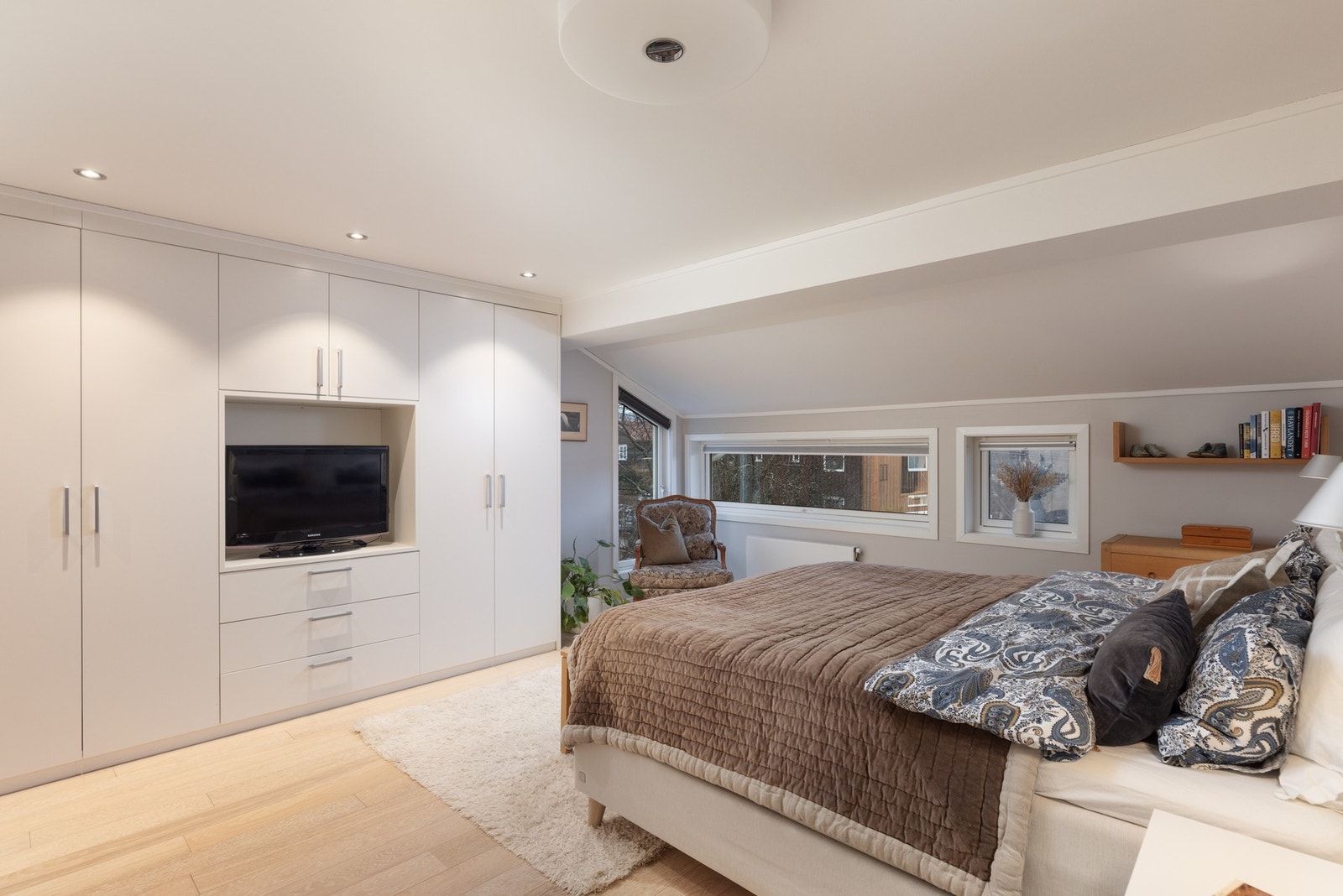 Her er det innebygd garderobeskap med skuffer, glatte fronter og nisje for tv-løsning Galleribilde