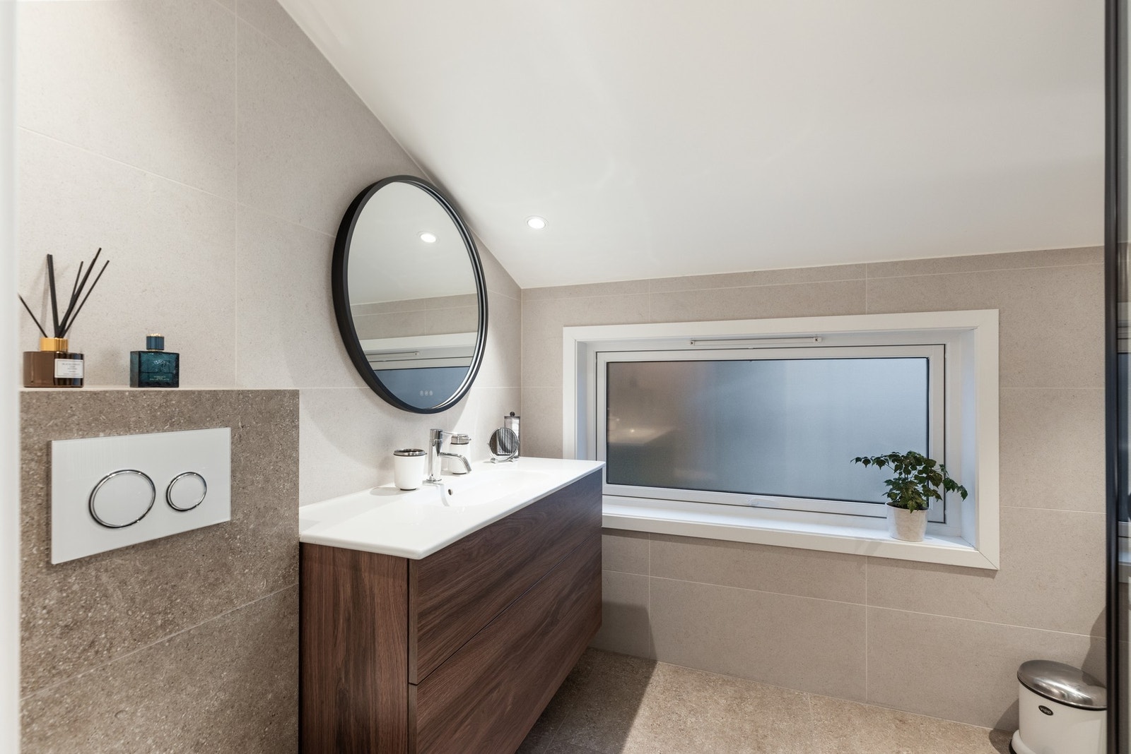 Bad med benkeskap under servant, dusj med dører i herdet glass og vegghengt WC Galleribilde