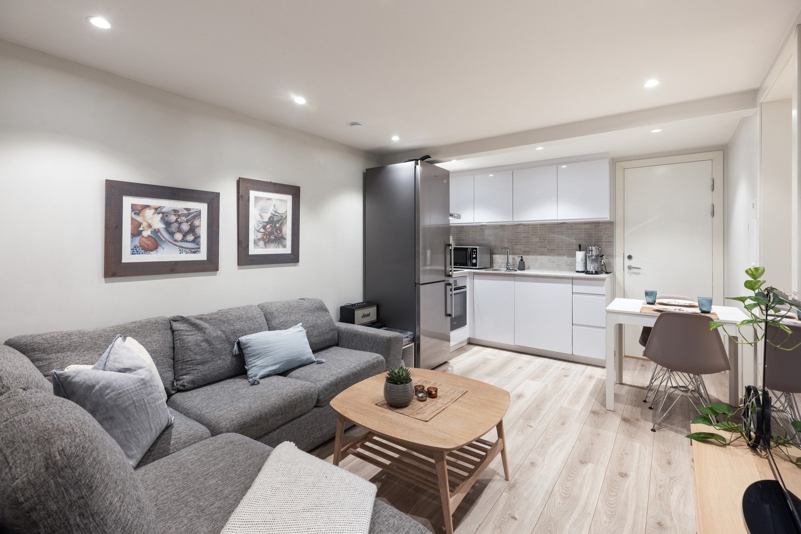 Stuen og kjøkkenet ligger i åpen løsning, med rom for en hyggelig, liten spiseplass i tillegg til sofagruppen Galleribilde