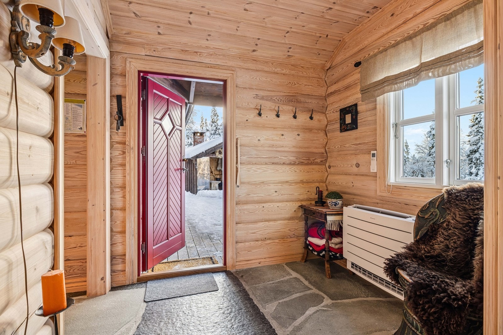 Hytta har en innbydende entré med god plass til å henge fra seg yttertøy og sko. Gulvet er belagt med skifer, noe som både gir et solid og praktisk underlag, spesielt på vinterstid. Galleribilde