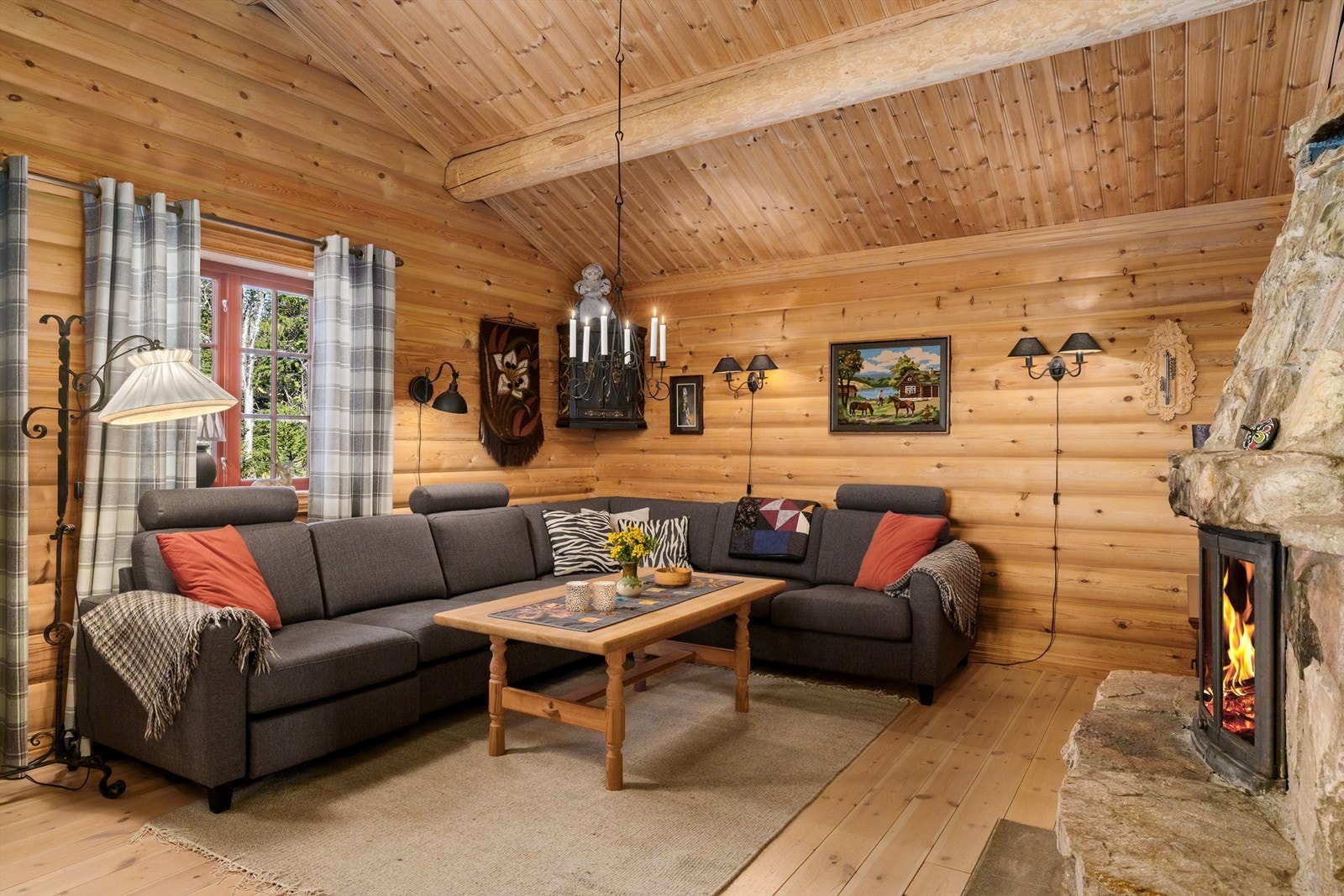 En romslig sofakrok inviterer til samvær foran peisen på kjølige kvelder. Galleribilde