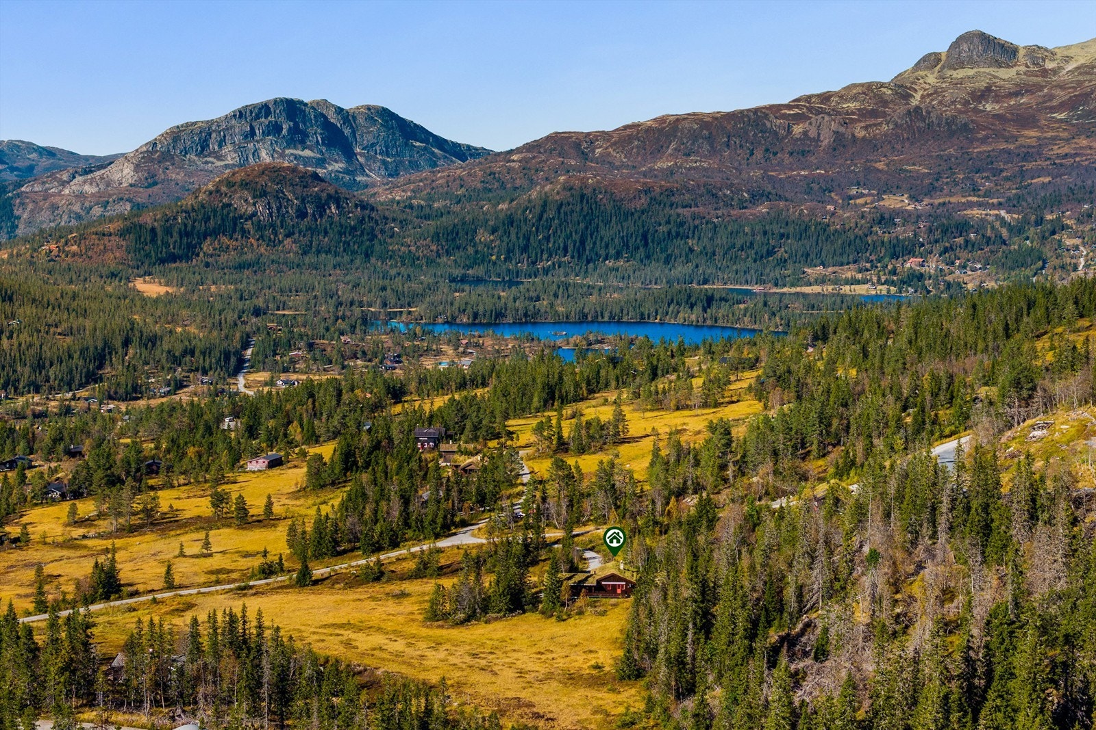 Landskapet rundt hytta er preget av fjell, skog og vann. Galleribilde
