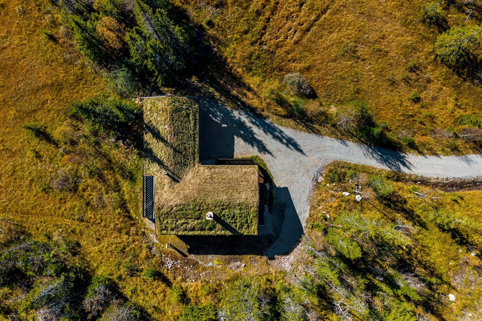 Hytta er kledd med torvtak som glir naturlig inn i landskapet. Galleribilde