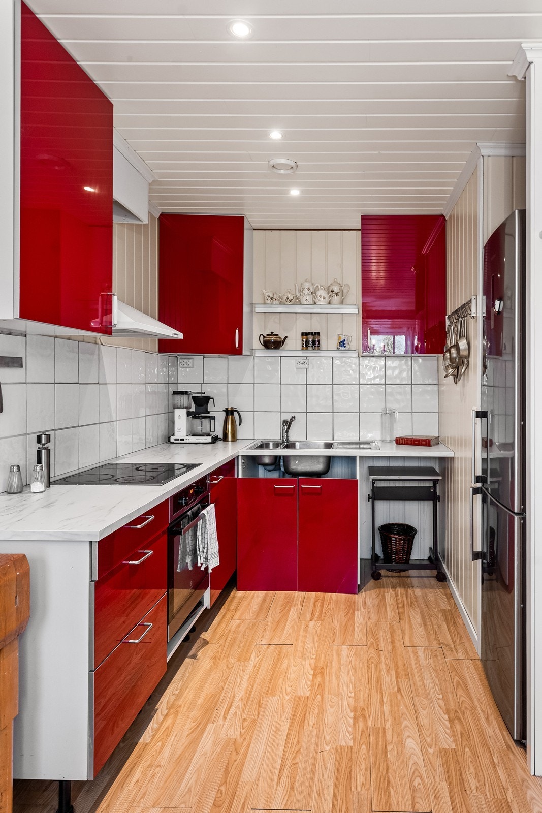 Kjøkkenet har innredning fra IKEA med slette fronter i rød høyglans og laminerte benkeplater Galleribilde