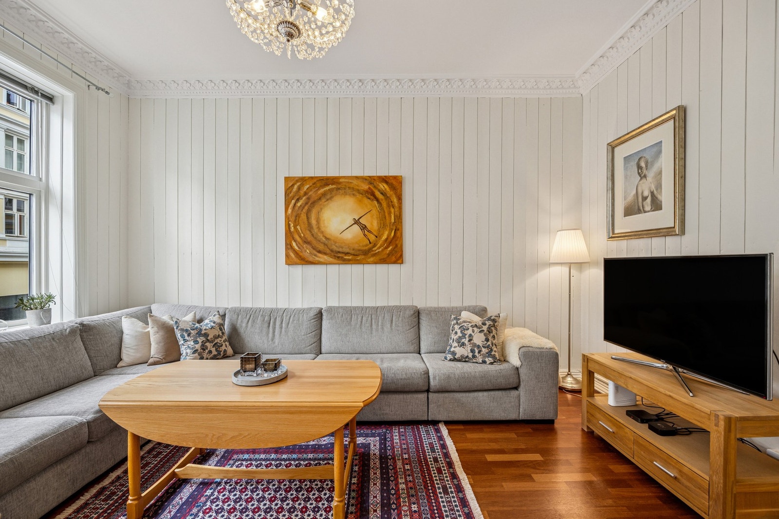 I stuen finner du en peis som sørger for ekstra hygge og varme på kalde dager.
Leiligheten har vakre, klassiske elementer som rosett, stukkatur og doble fløydører. Galleribilde