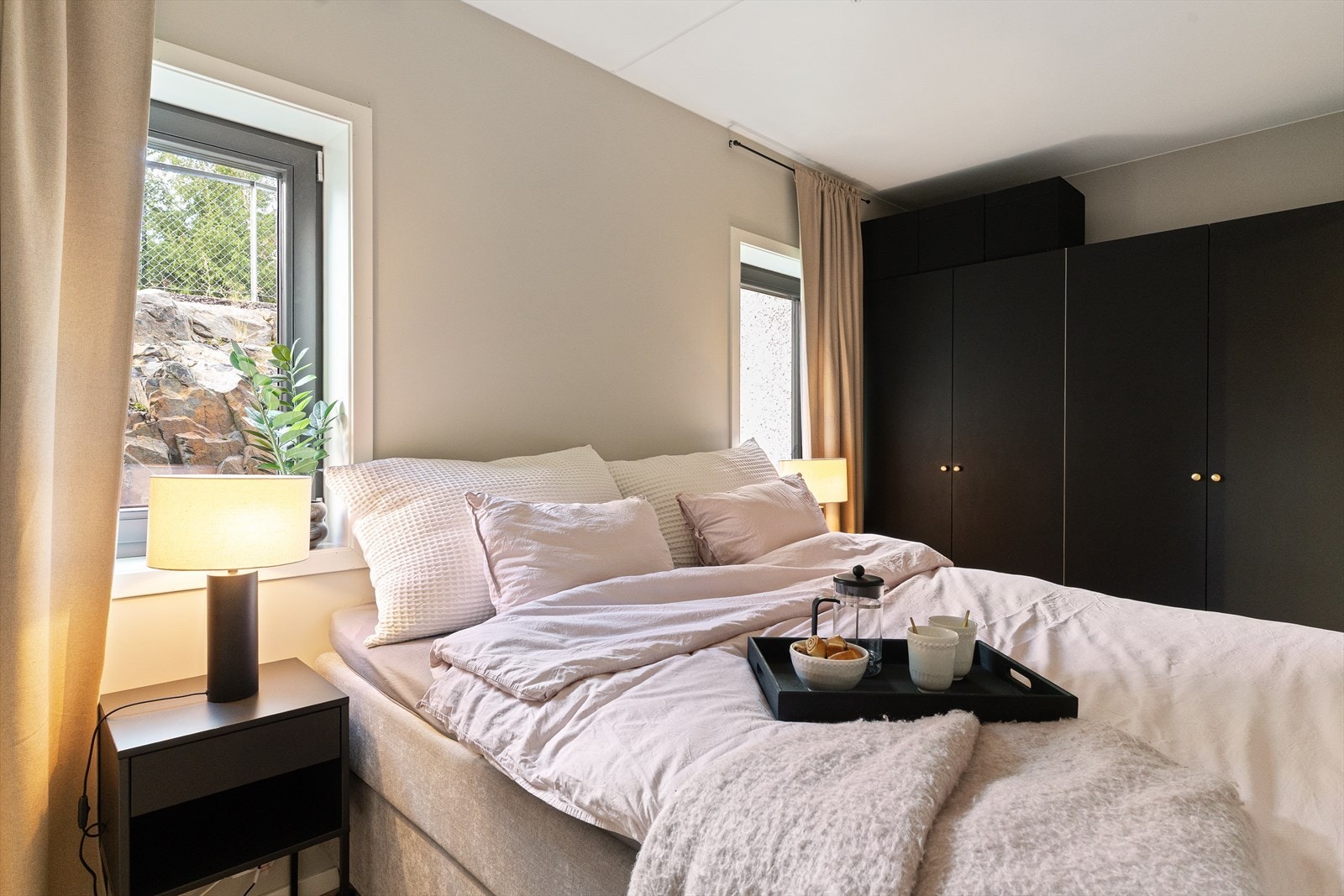 Medfølgende på den ene veggen, har man vegg til vegg garderobeløsning i sort utførelse, med lekre håndtak i rosegull. Galleribilde