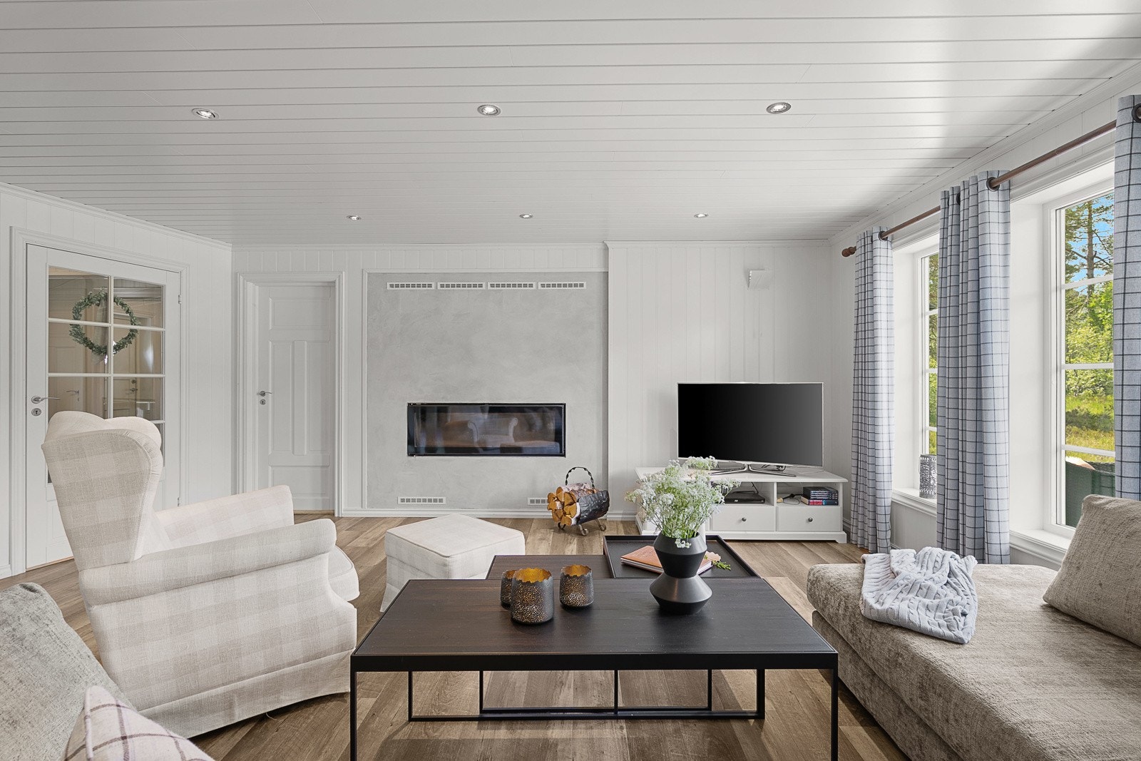 Stuen er innredet med en elegant peisinnsats som ikke bare gir god varme, men også understreker hyttas stilrene og innbydende uttrykk. Galleribilde