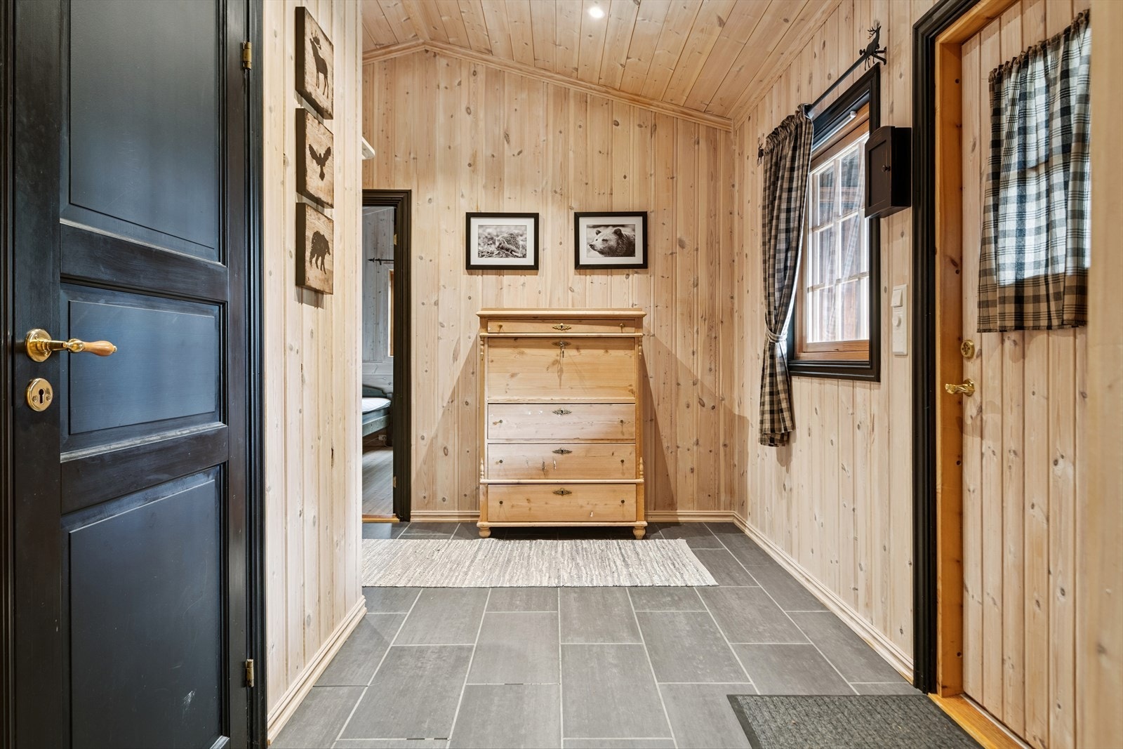 Romslig entre med fliser på gulv og downlights i tak. Galleribilde